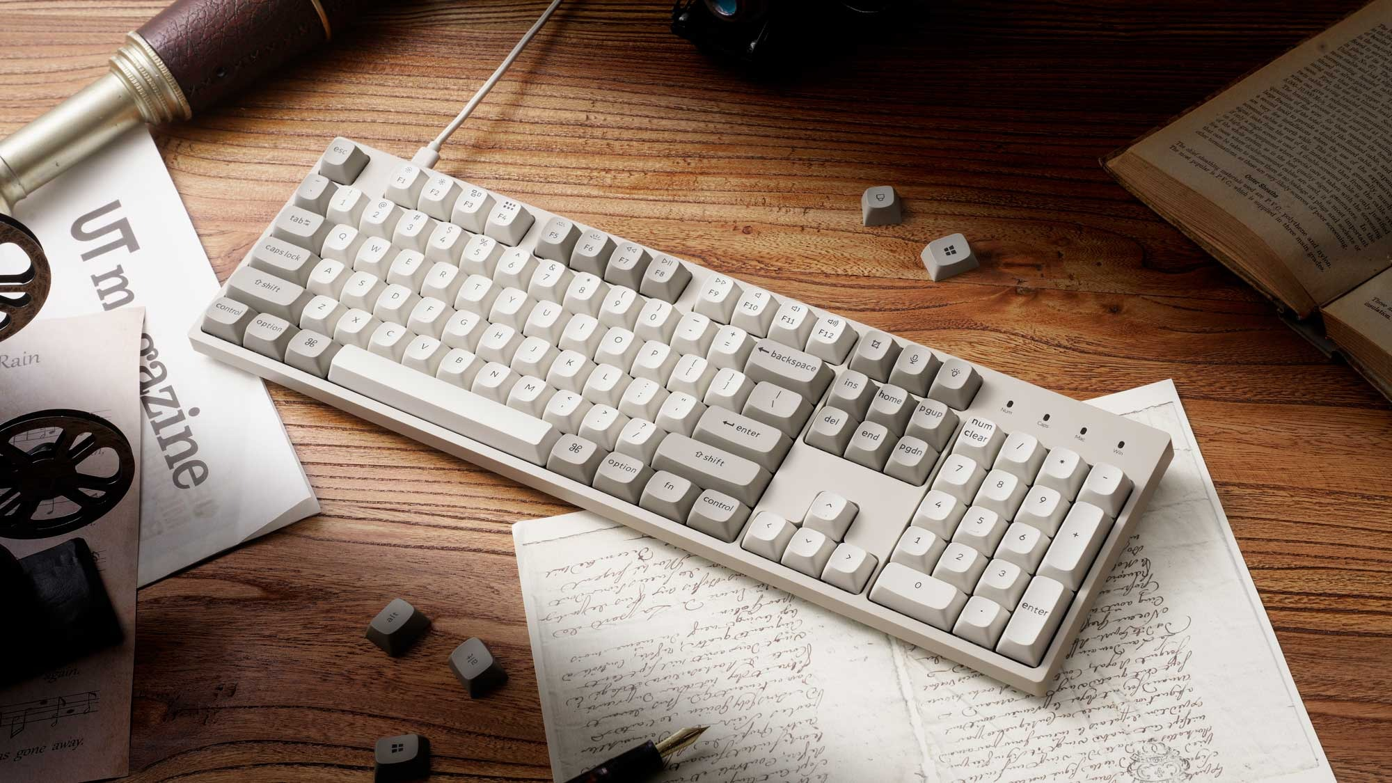 Jasna klawiatura na drewnianym stole ze starymi dokumentami i lunetą.