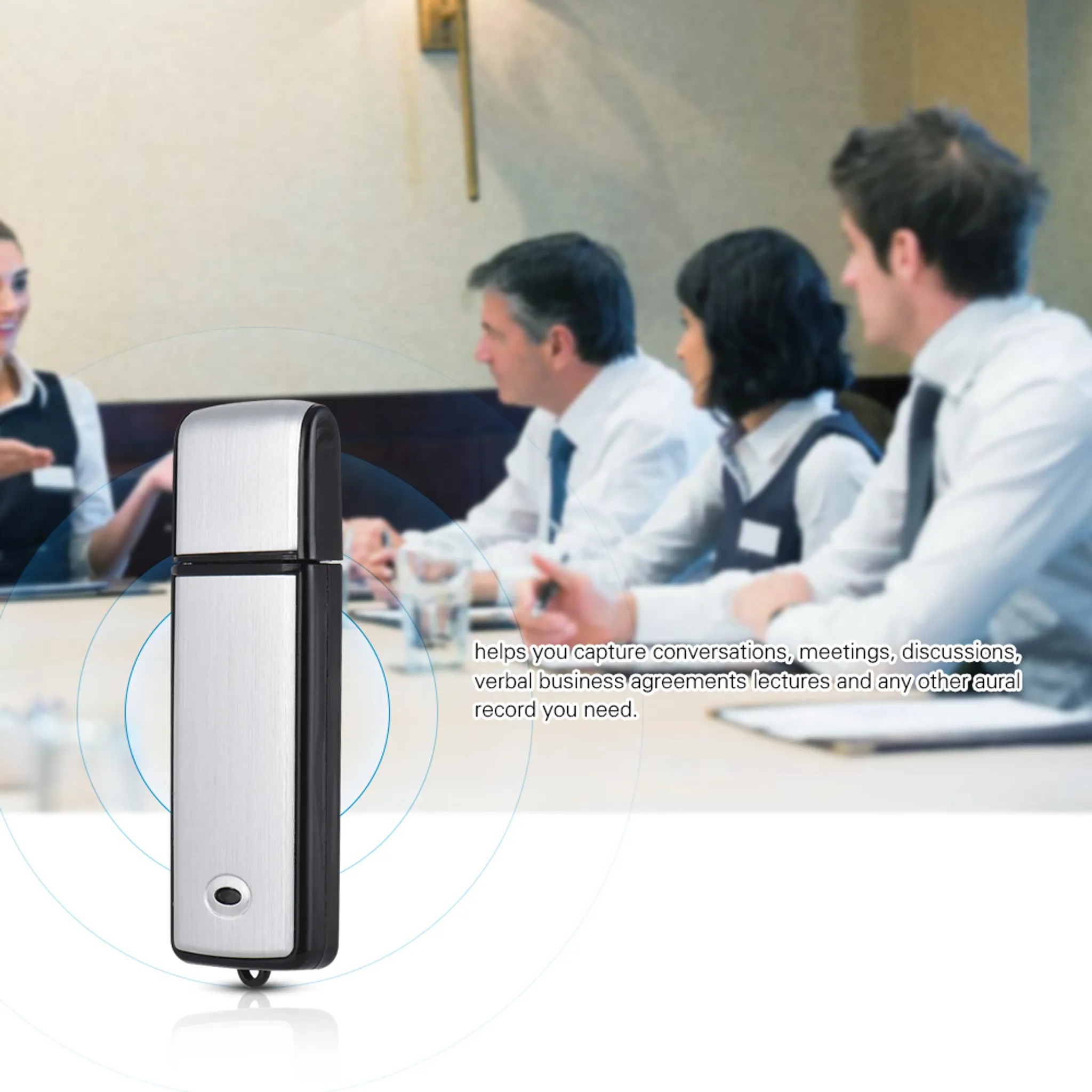 Ein silberner und schwarzer USB-Diktiergerät sitzt auf einem Tisch mit Personen in einer Besprechung dahinter.