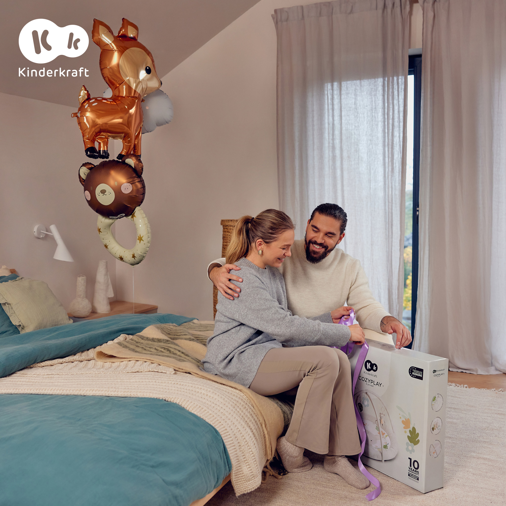 Ein Paar öffnet eine Geschenkbox mit Luftballons im Hintergrund.