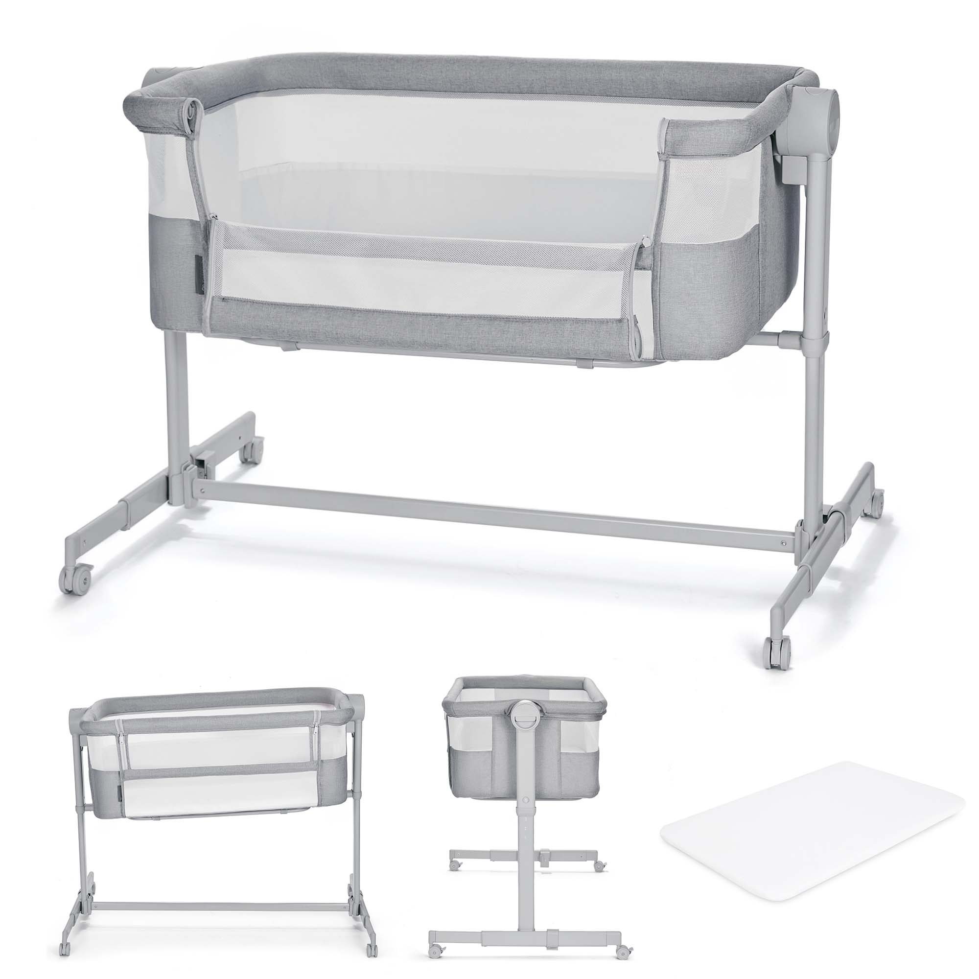 Ein graues Babybett mit Rädern und einem weißen Einsatz. Daneben ein weiteres Bett und eine weiße Matte.