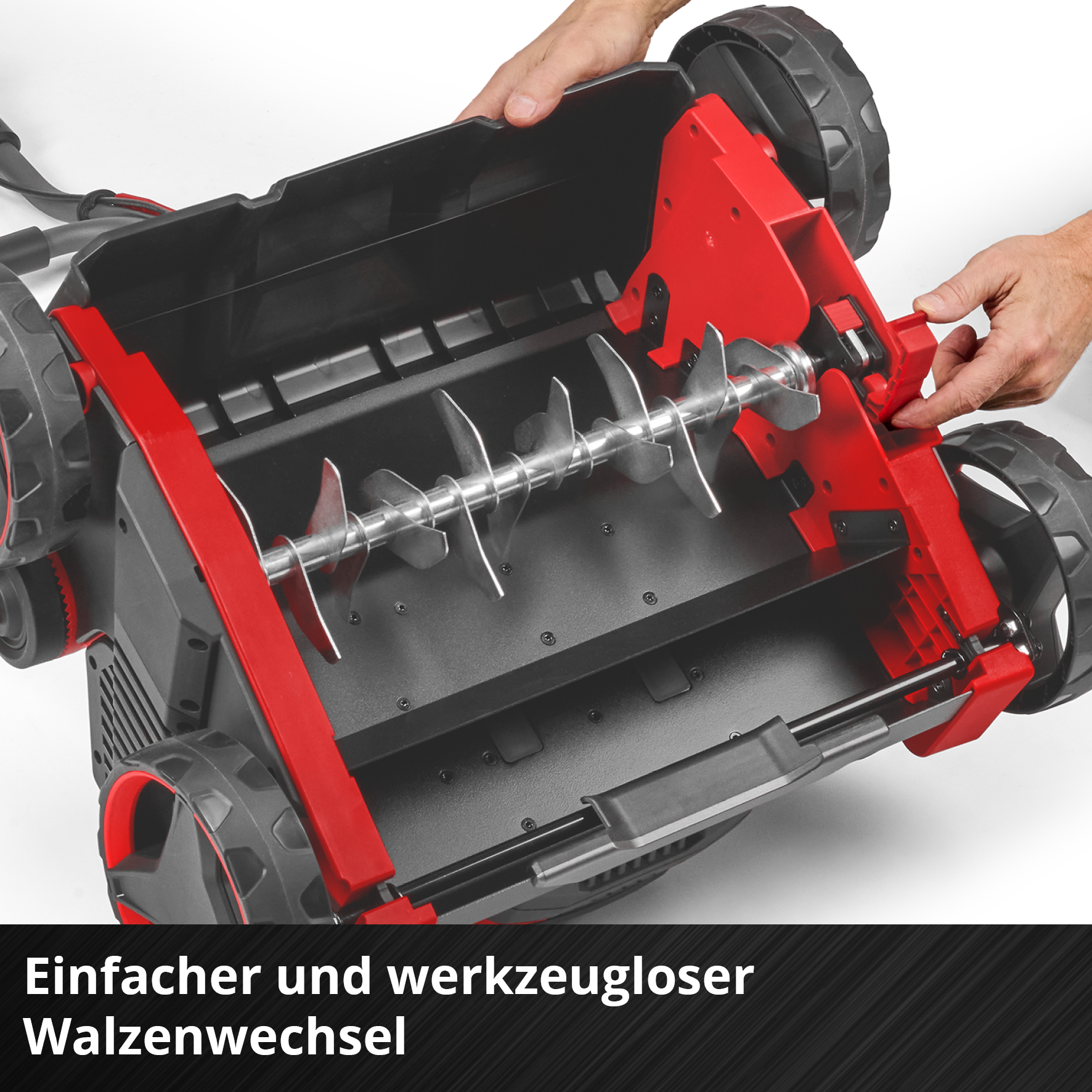 Hände wechseln einen roten und schwarzen Rasenlüfter-Zylinder aus.