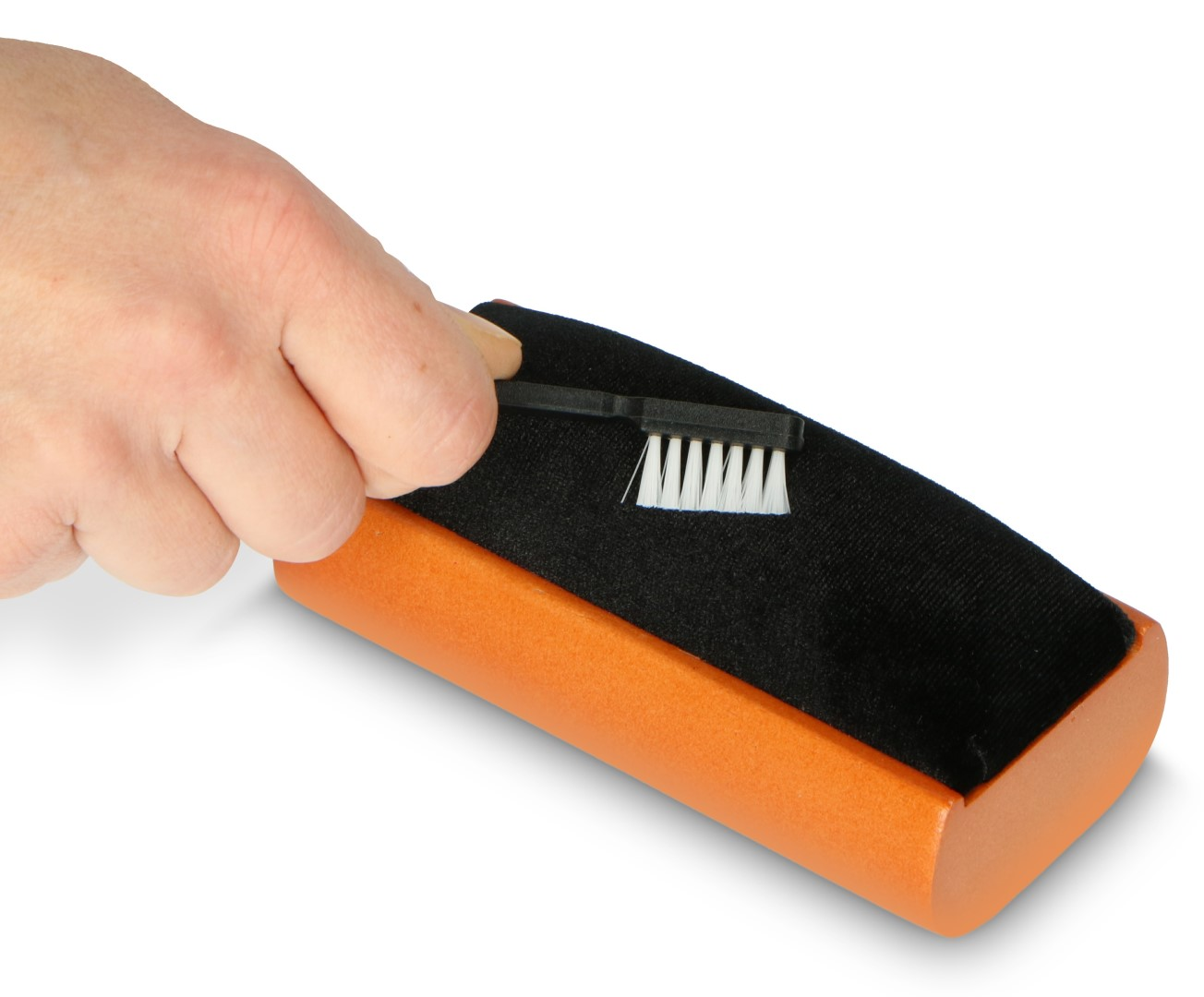 Dłoń z małą szczoteczką czyści pomarańczowy przedmiot z czarną tkaniną.