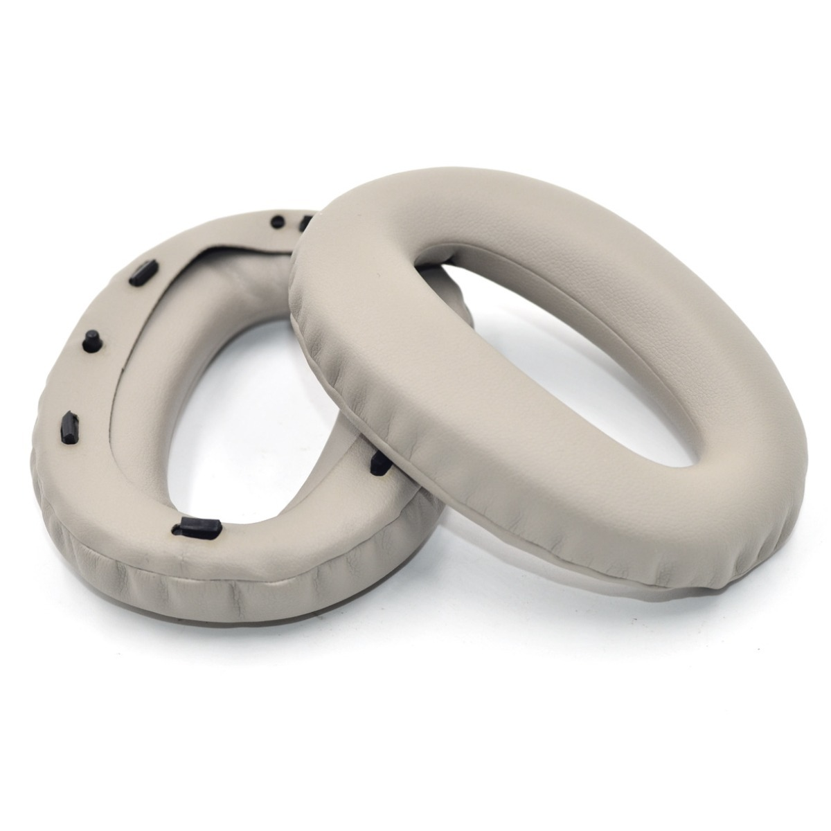 Dos almohadillas grises claras para auriculares yacen una al lado de la otra.