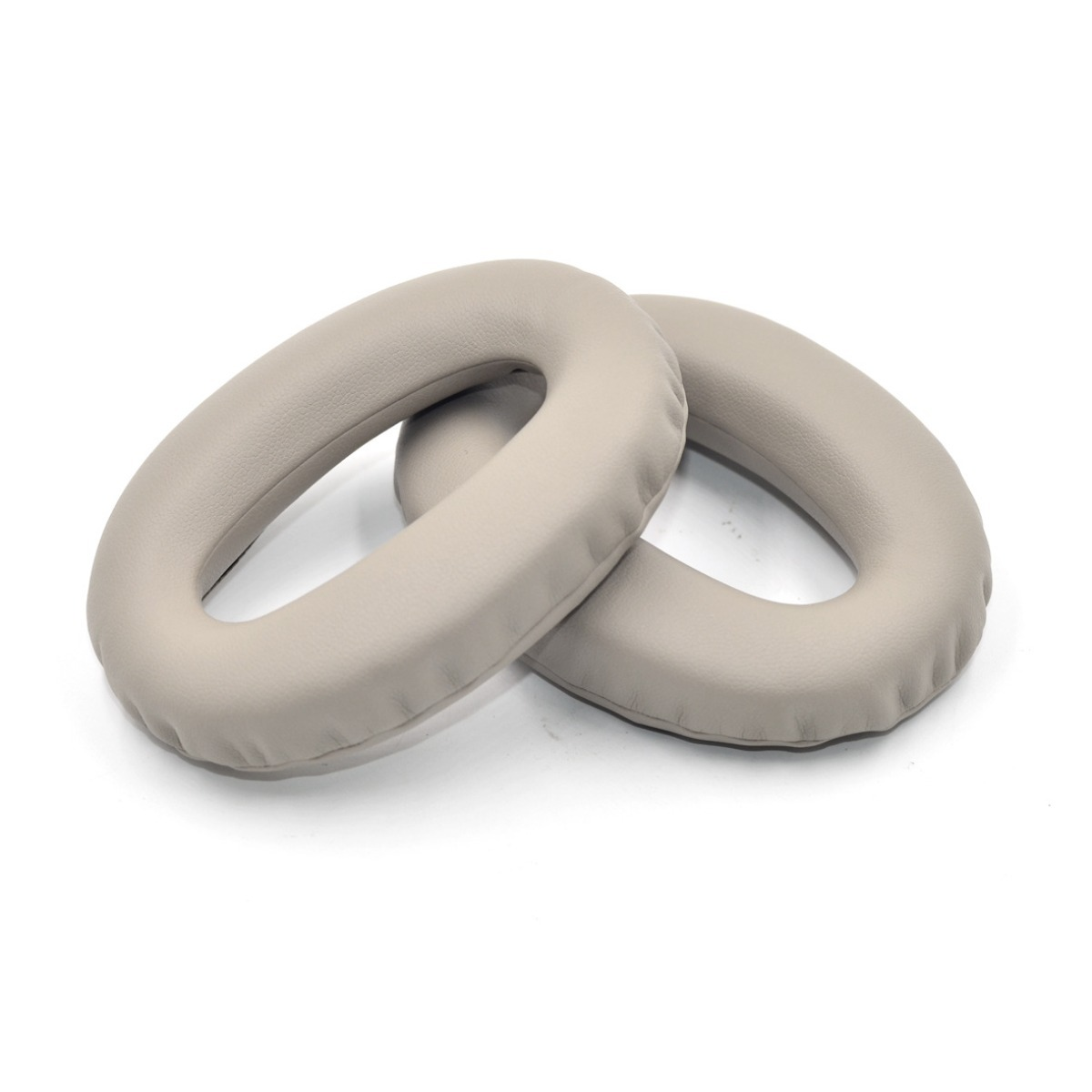 Dos almohadillas beige para auriculares yacen una al lado de la otra.