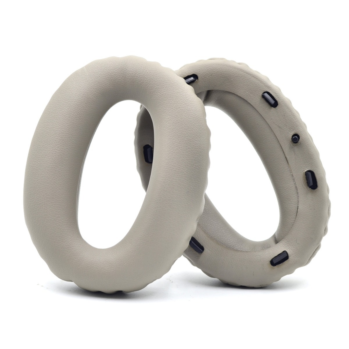 Dos almohadillas grises claras para auriculares con clips negros, aisladas en blanco.