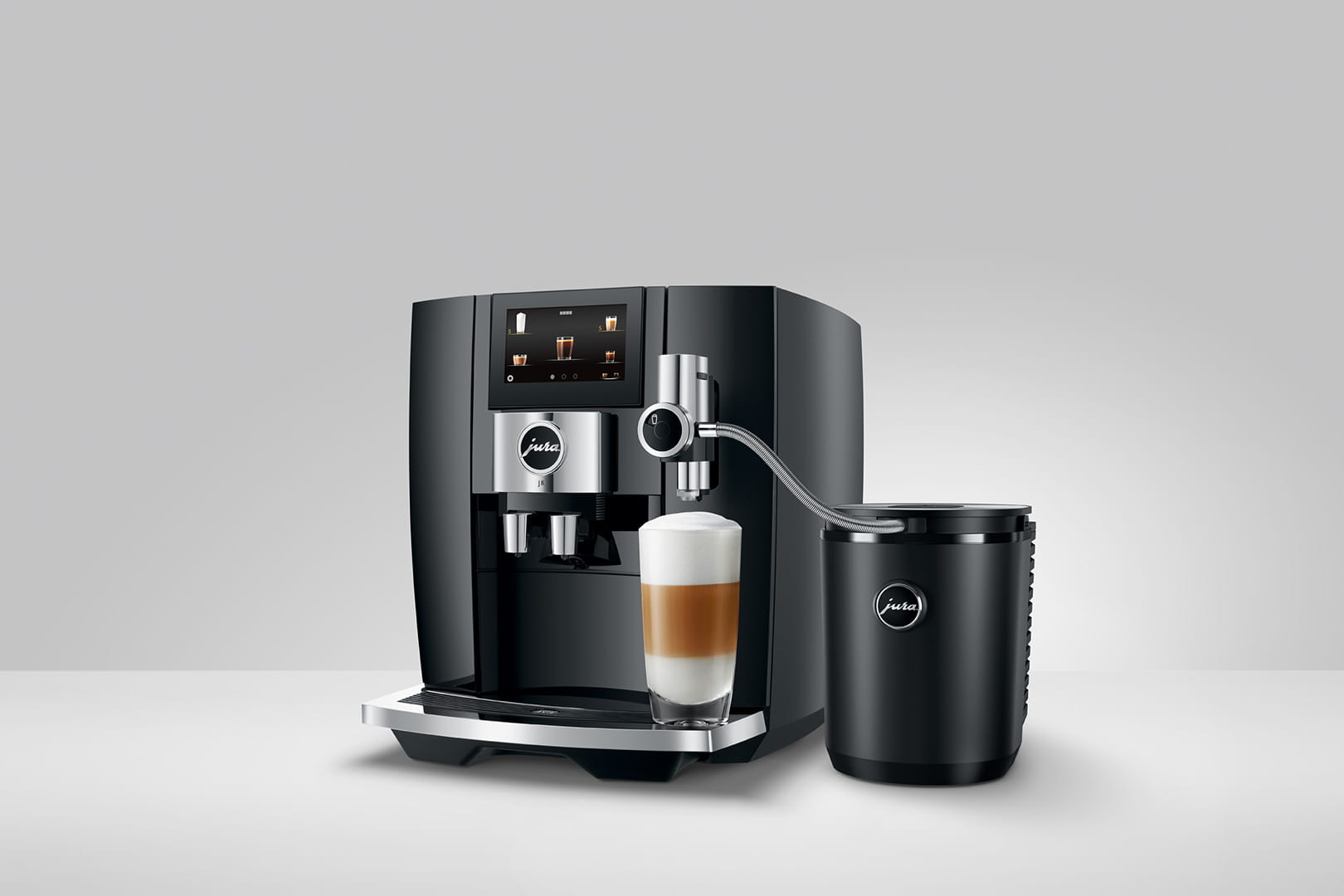 Macchina da caffè nera con contenitore del latte e un bicchiere di latte macchiato.