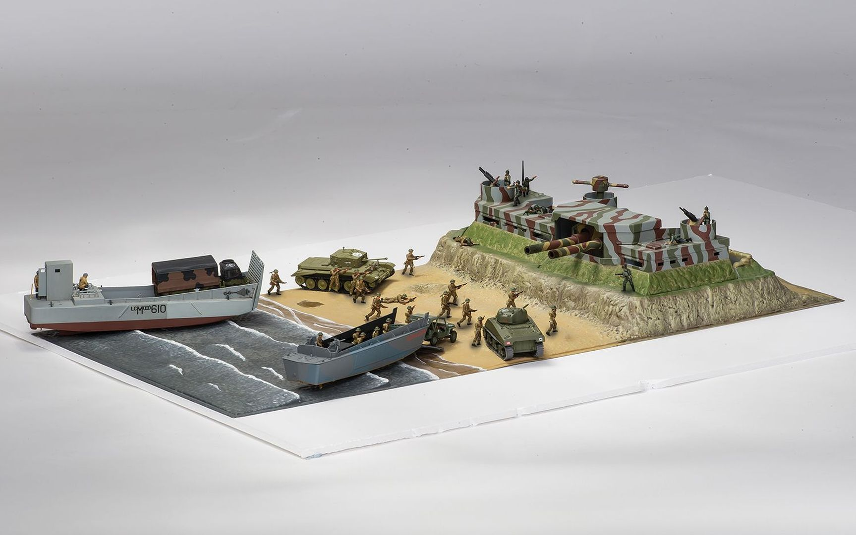 Diorama przedstawia inwazję desantową z czołgami i żołnierzami na plaży.