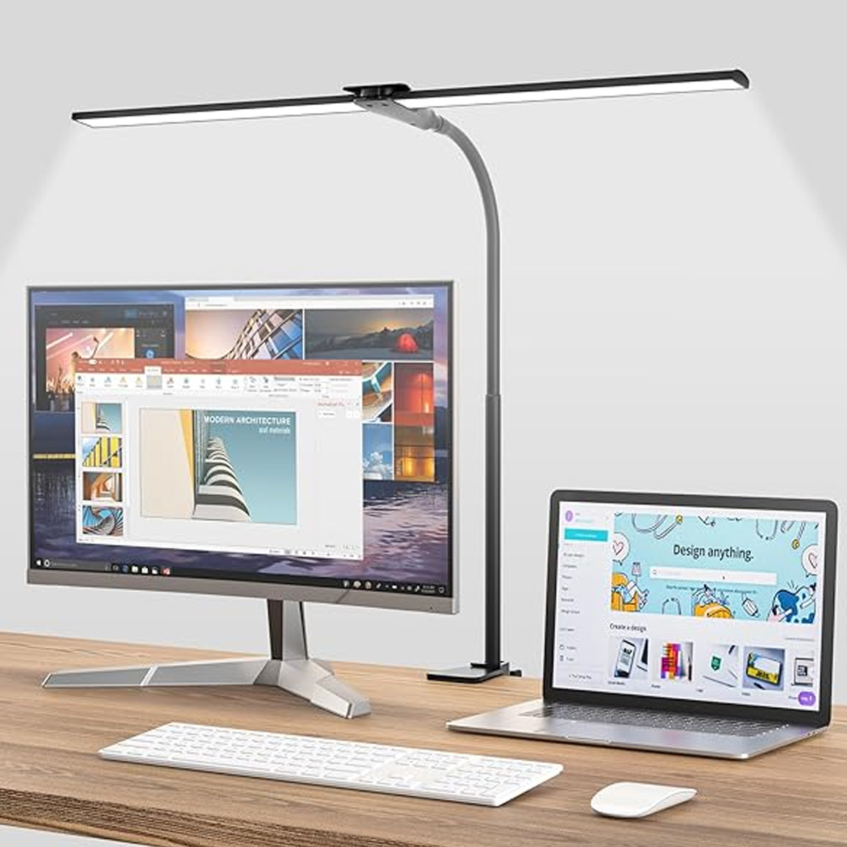 Ein Schreibtisch mit Monitor, Laptop, Tastatur, Maus und einer Schreibtischlampe.