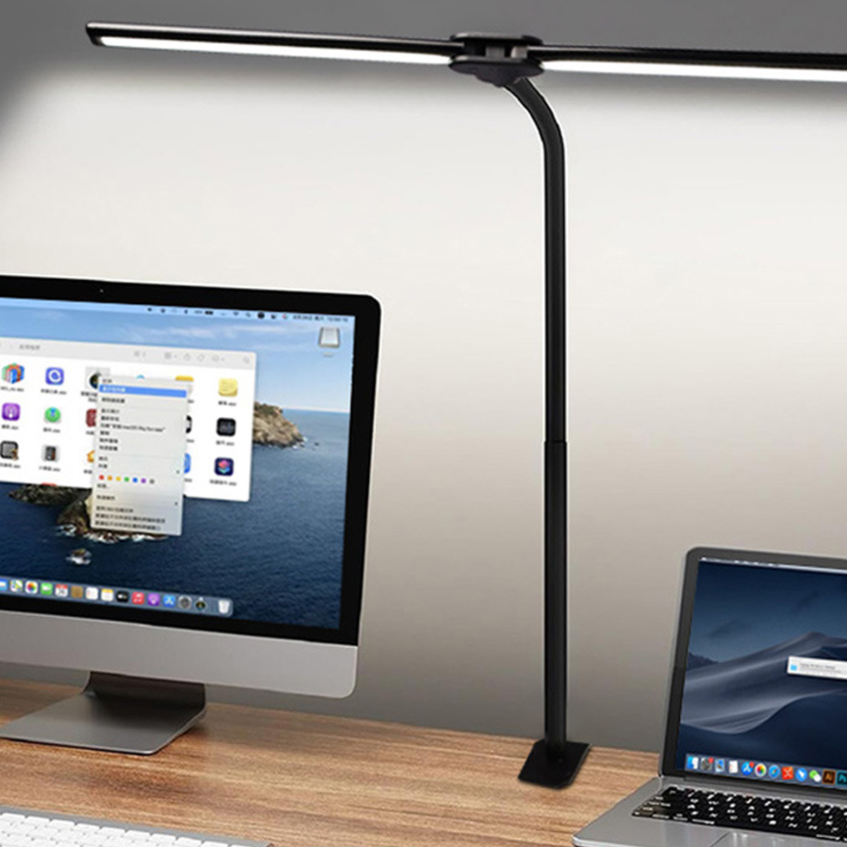 Eine schwarze LED-Schreibtischlampe beleuchtet einen Monitor und Laptop auf einem Holztisch.
