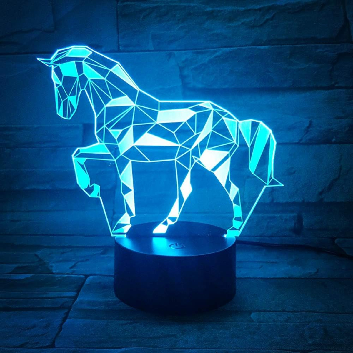 Eine geometrische 3D-Pferdelampe leuchtet in Blau auf einem dunklen Sockel.