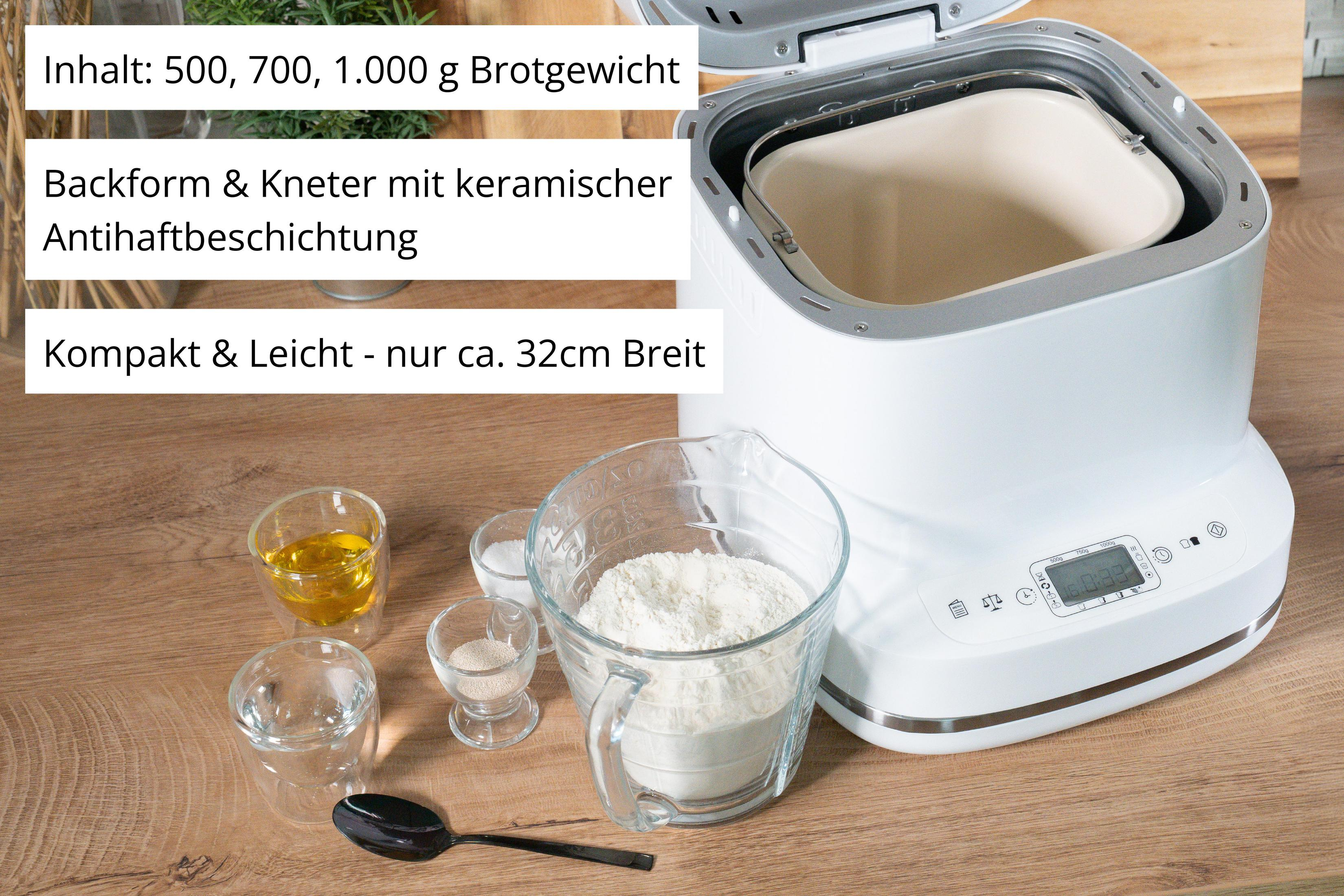 Ein weißer Brotbackautomat mit Zutaten wie Mehl, Öl und Hefe auf einem Holztisch.