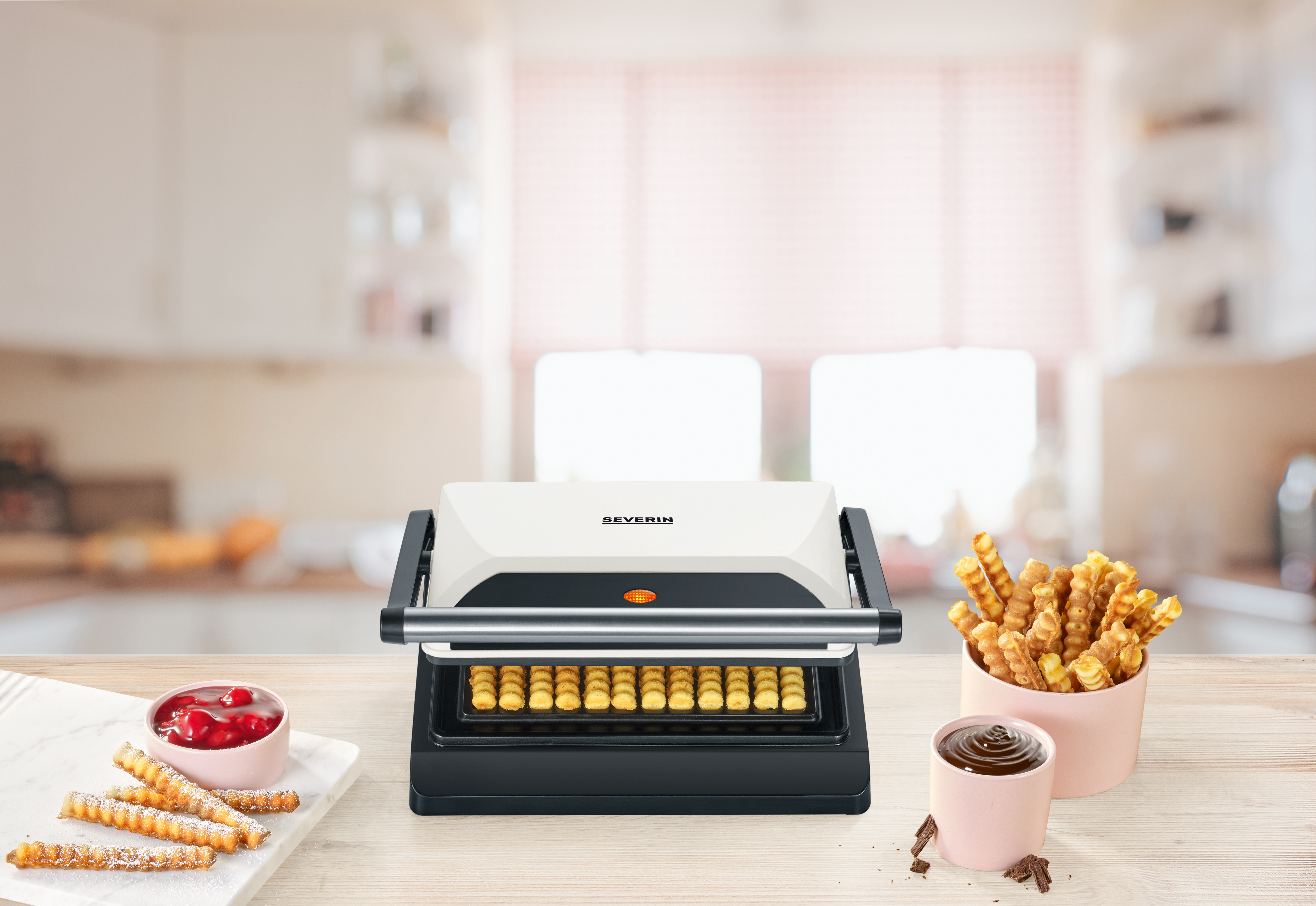 Ein Waffeleisen mit fertigen Waffeln, Kirschen und Schokolade.