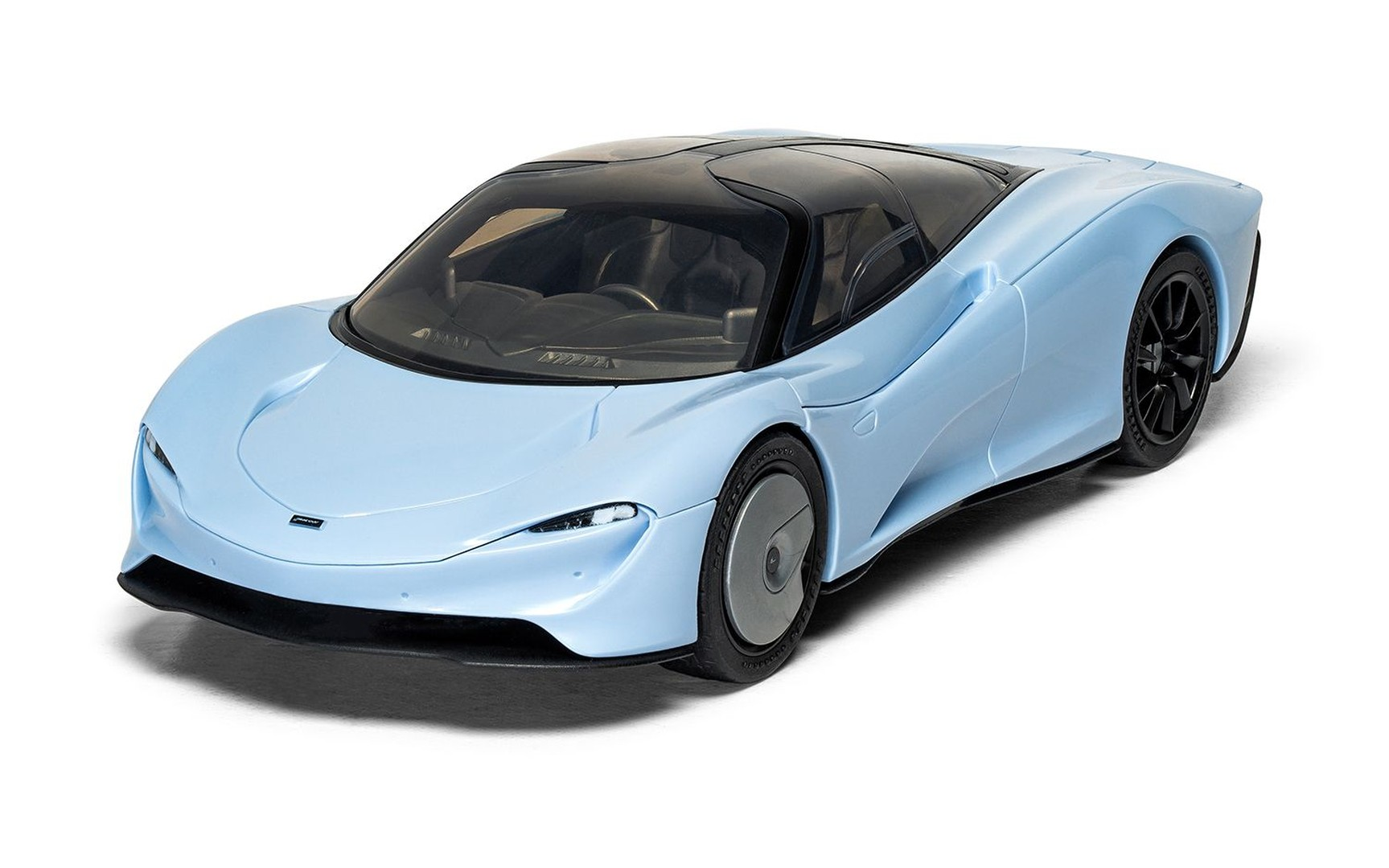 Jasnoniebieski McLaren z czarnym dachem i felgami na białym tle.