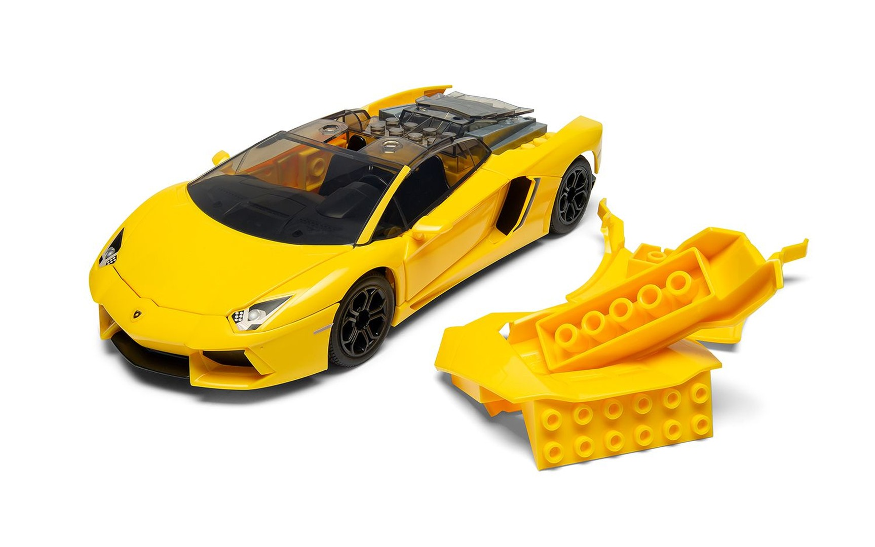 Żółty samochód sportowy Lego z przezroczystym dachem, obok żółtych części Lego.