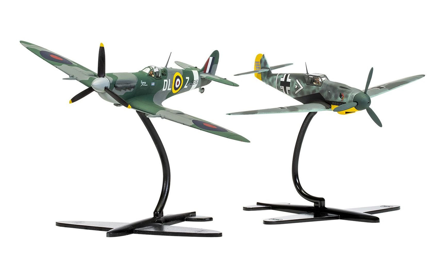 Dwa modele samolotów, zielona Spitfire i szara Bf 109, na stojakach.