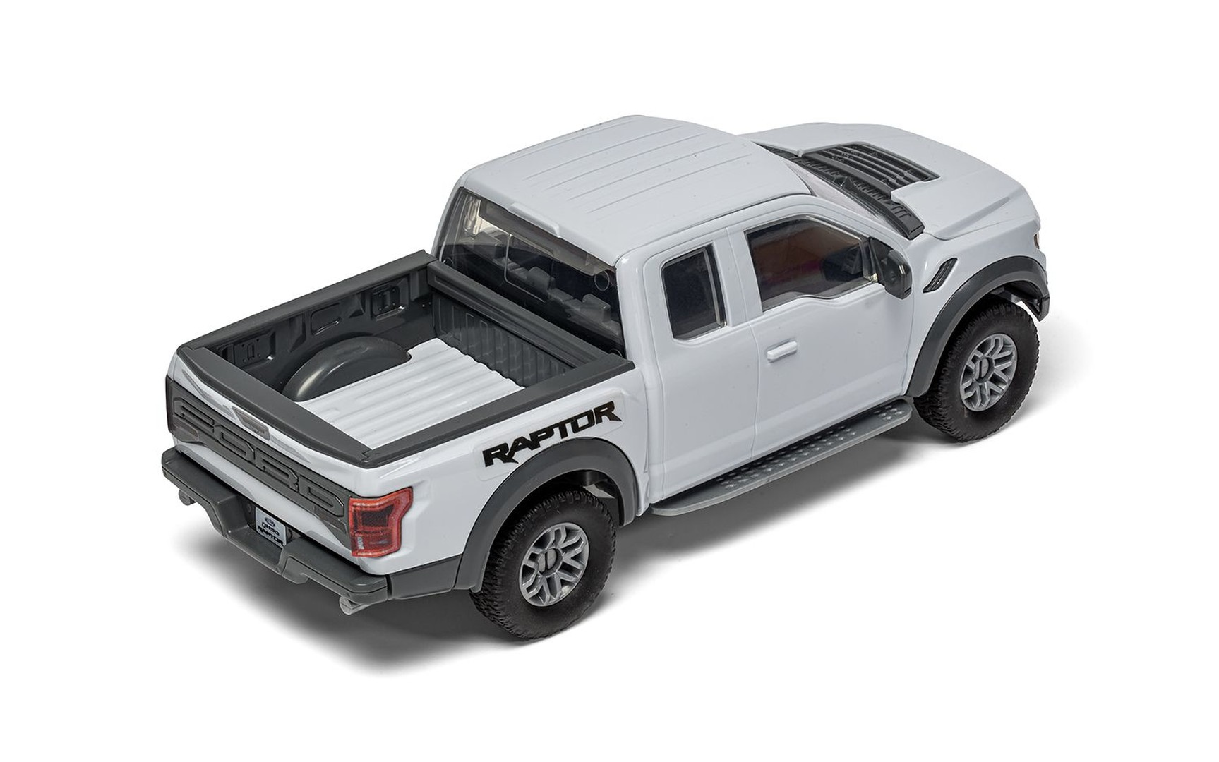Biały Ford Raptor zabawkowy z ciemnymi kołami i stopniami.