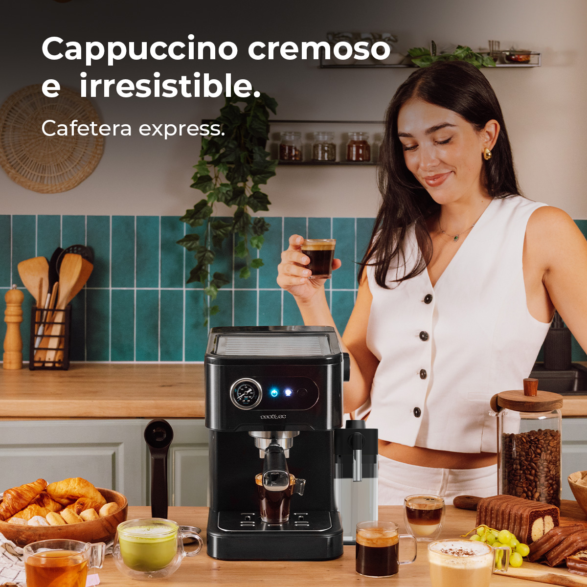 Eine Frau hält einen Espresso vor einer Kaffeemaschine mit Gebäck und Kaffee auf dem Tisch.