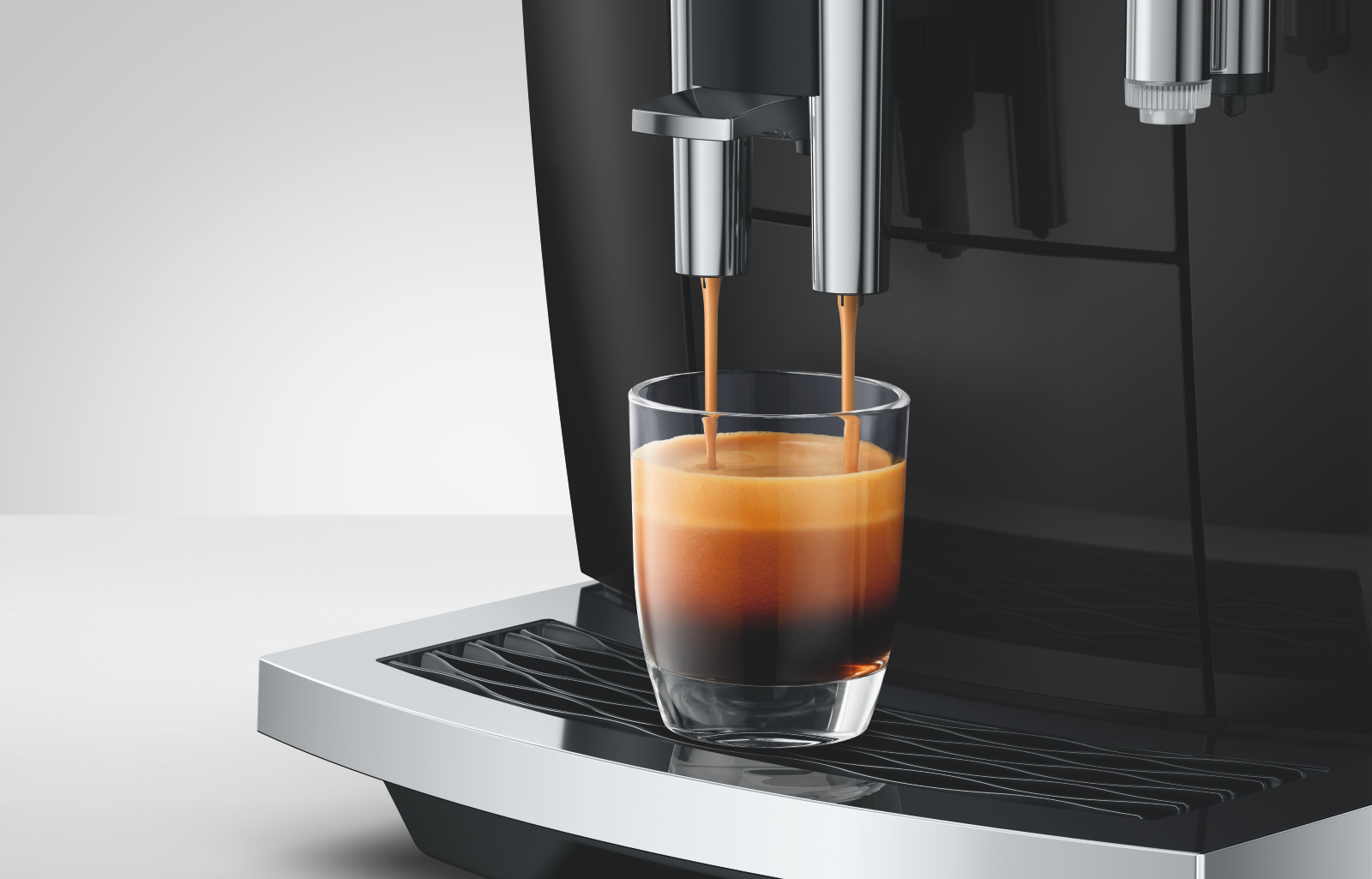 Una macchina per espresso prepara il caffè in un bicchiere.