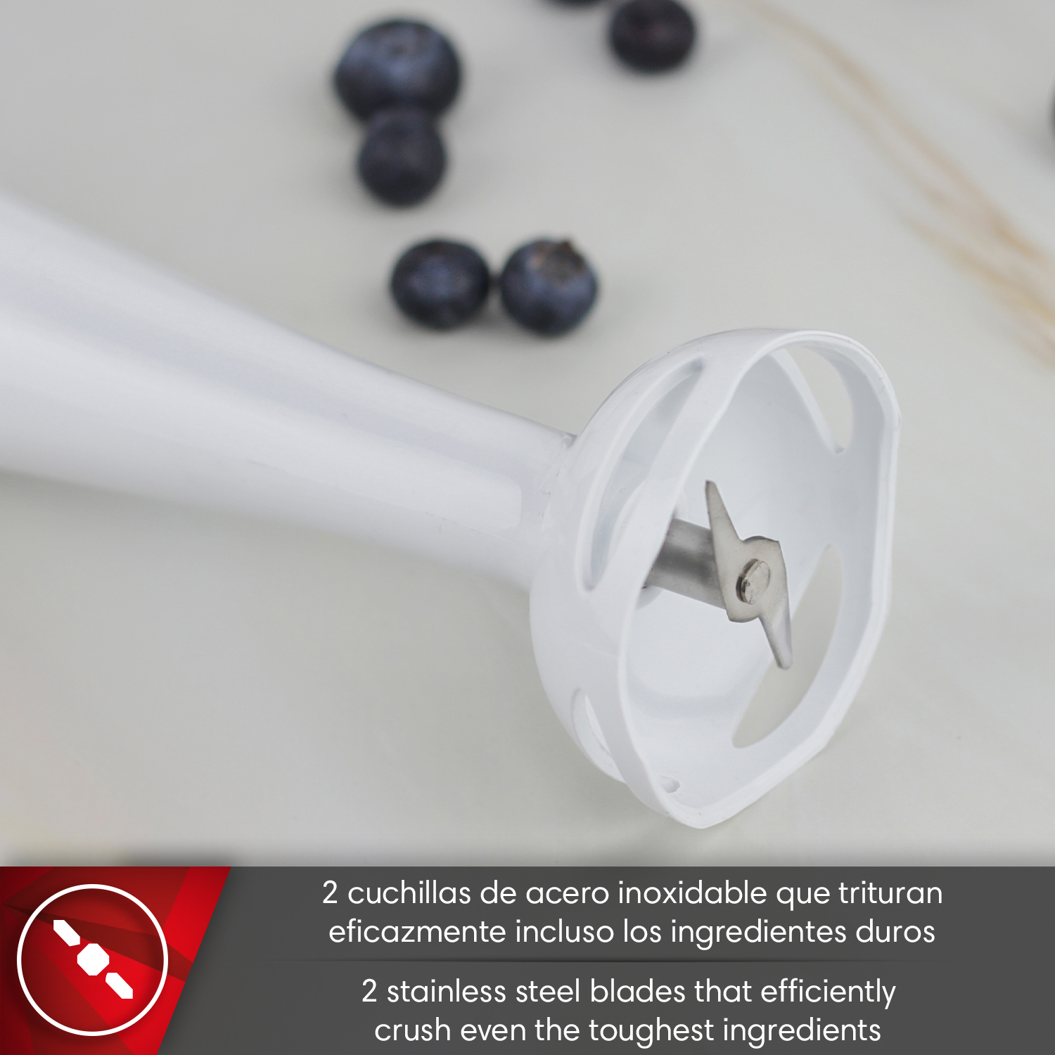 Primer plano de batidora de inmersión blanca con dos cuchillas de acero inoxidable y arándanos.