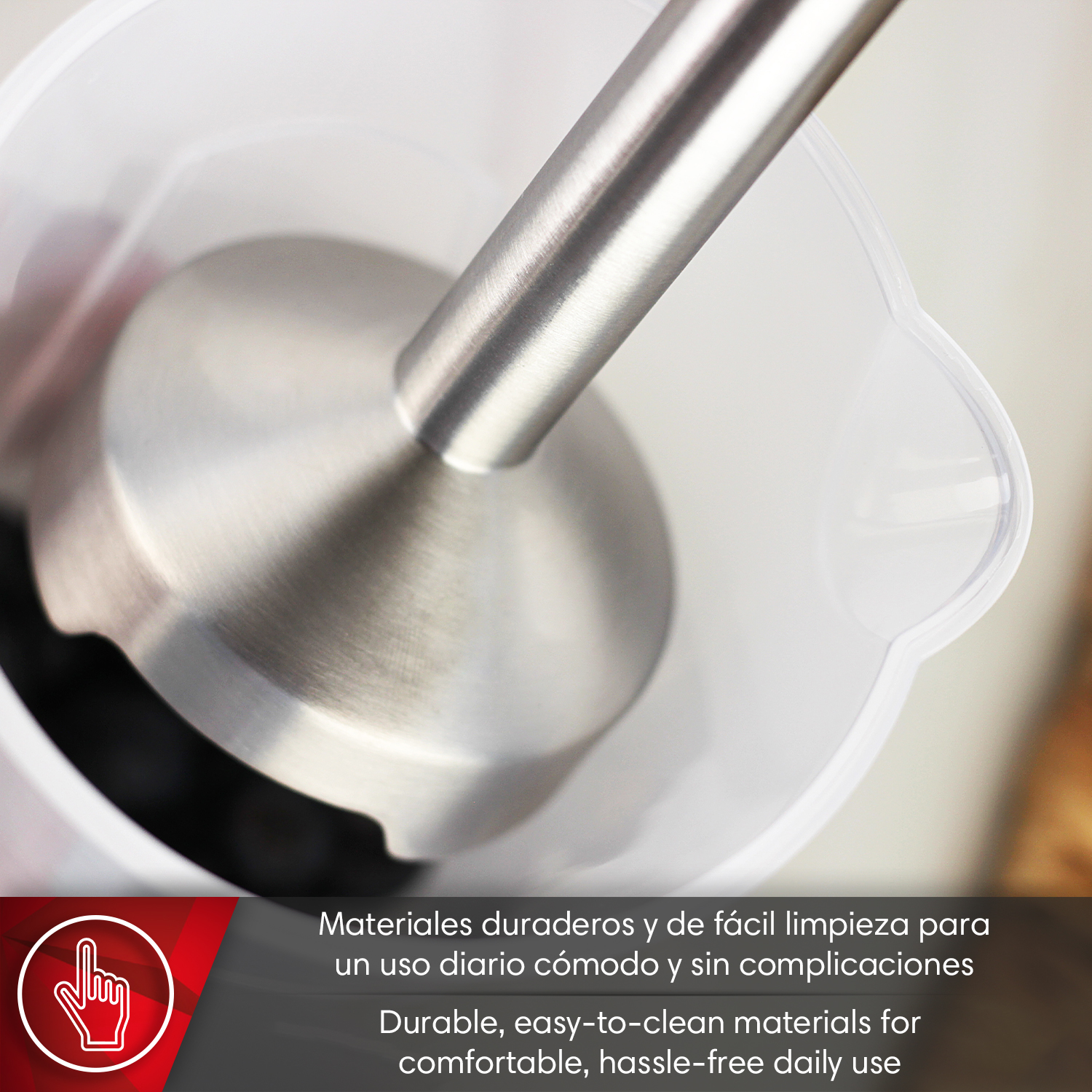 Pie de batidora de inmersión de acero inoxidable en vaso transparente.