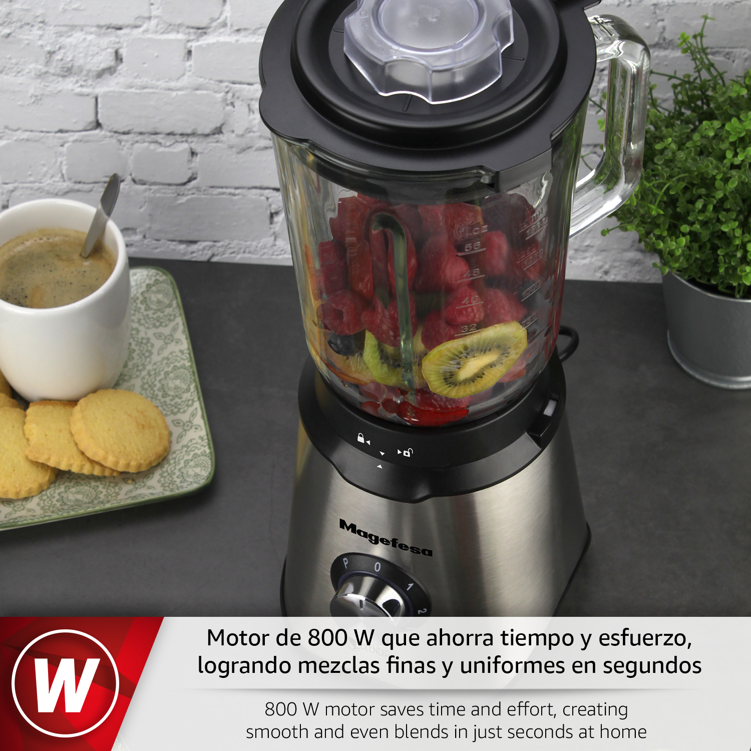 Una licuadora con fruta y una taza de café sobre una mesa.