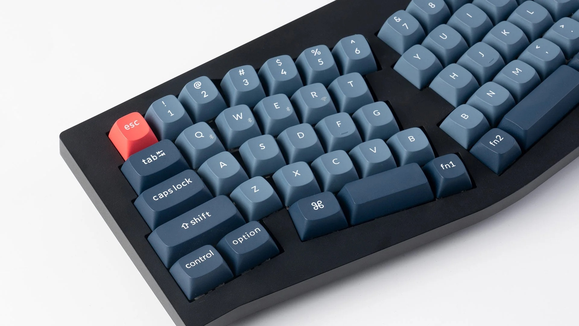 Zbliżenie klawiatury z niebieskimi i granatowymi klawiszami. Klawisz Esc jest czerwony.