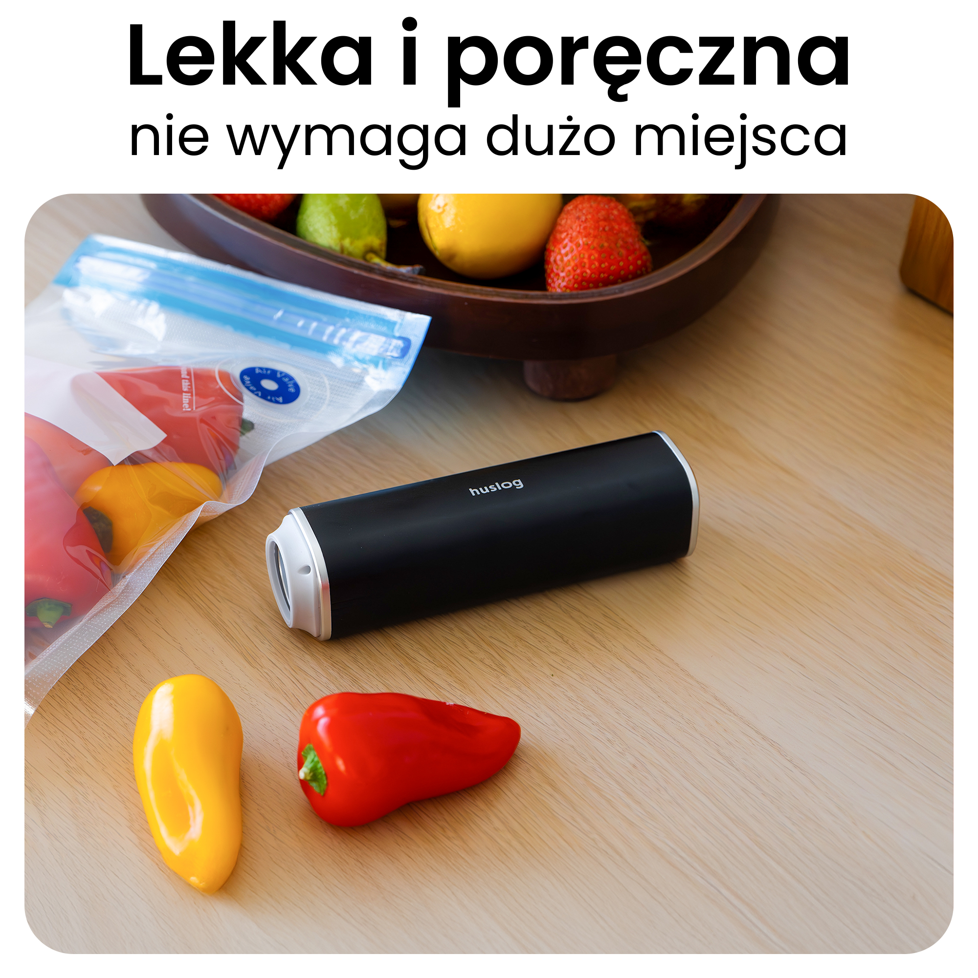 Czarny zamykacz próżniowy obok papryki i miski z owocami na drewnianym stole.