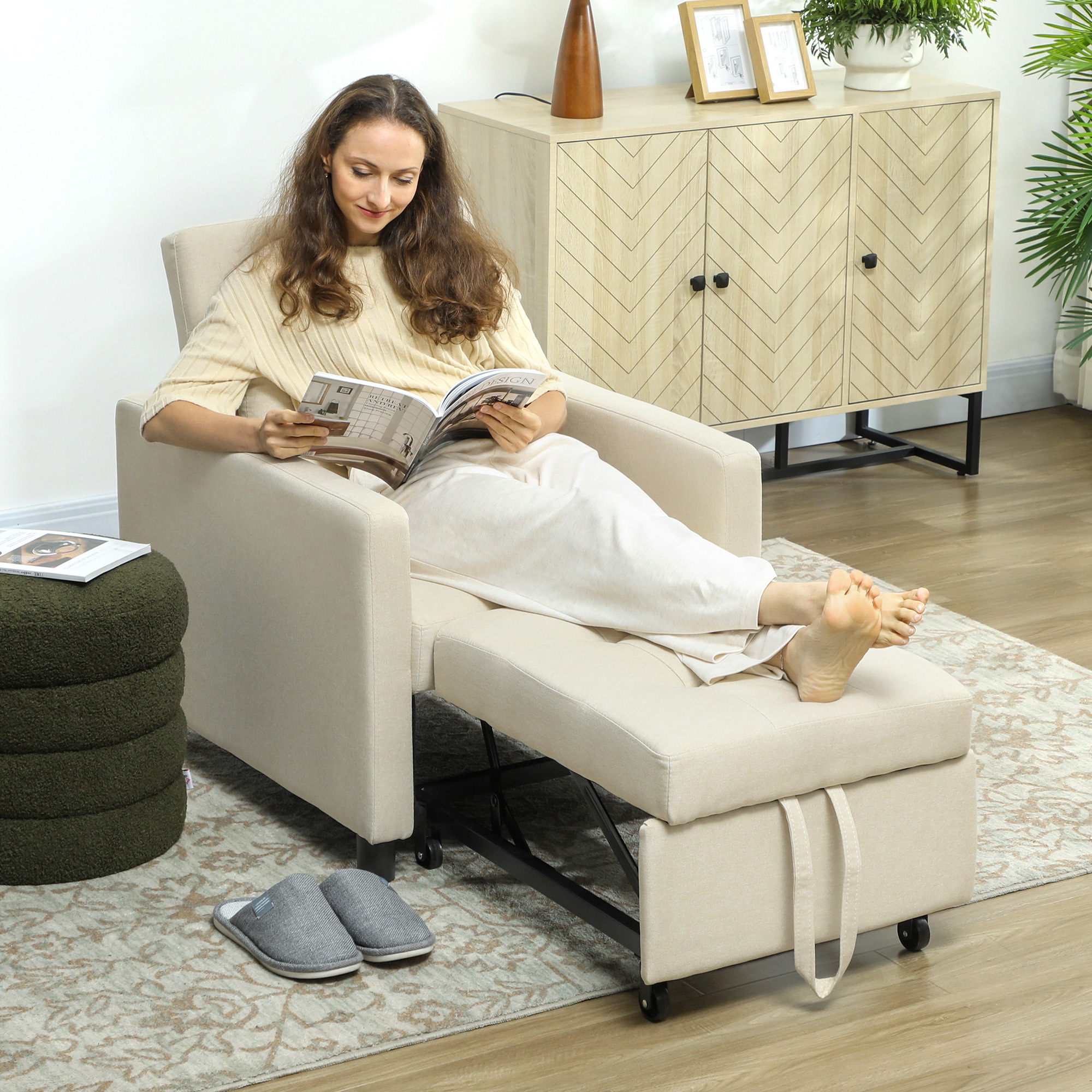 Una mujer lee una revista en un sillón beige con reposapiés extendido.