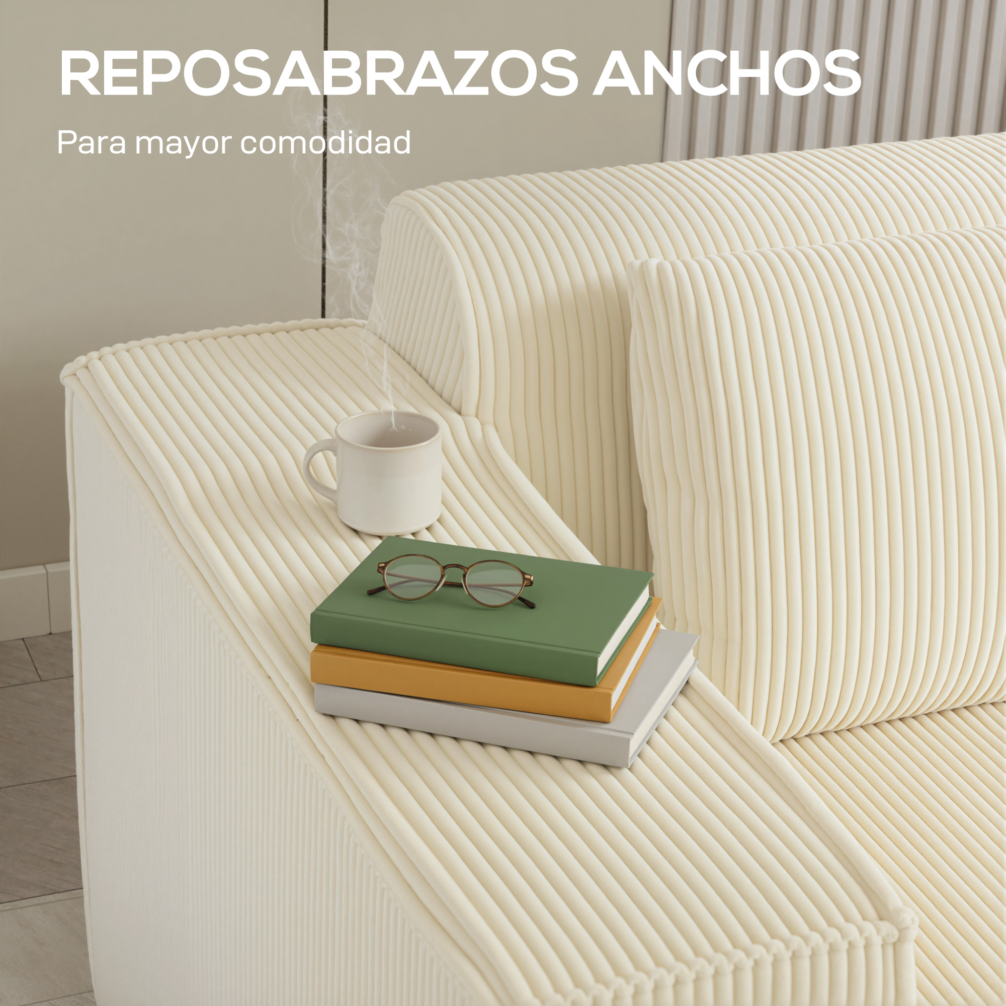 Un sofá color crema con reposabrazos anchos, libros, gafas y una taza humeante.