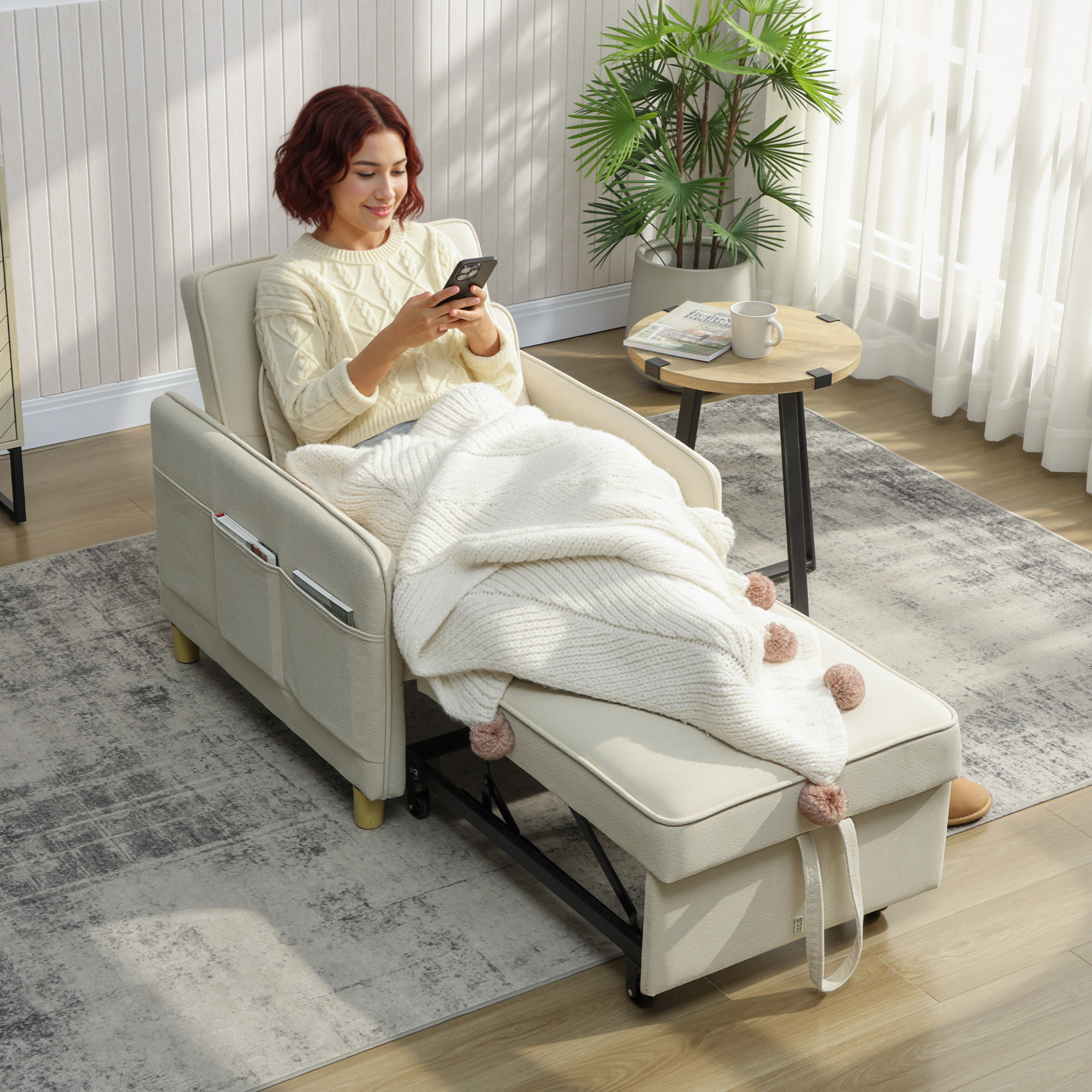 Una mujer se sienta en un sofá cama beige usando su teléfono.
