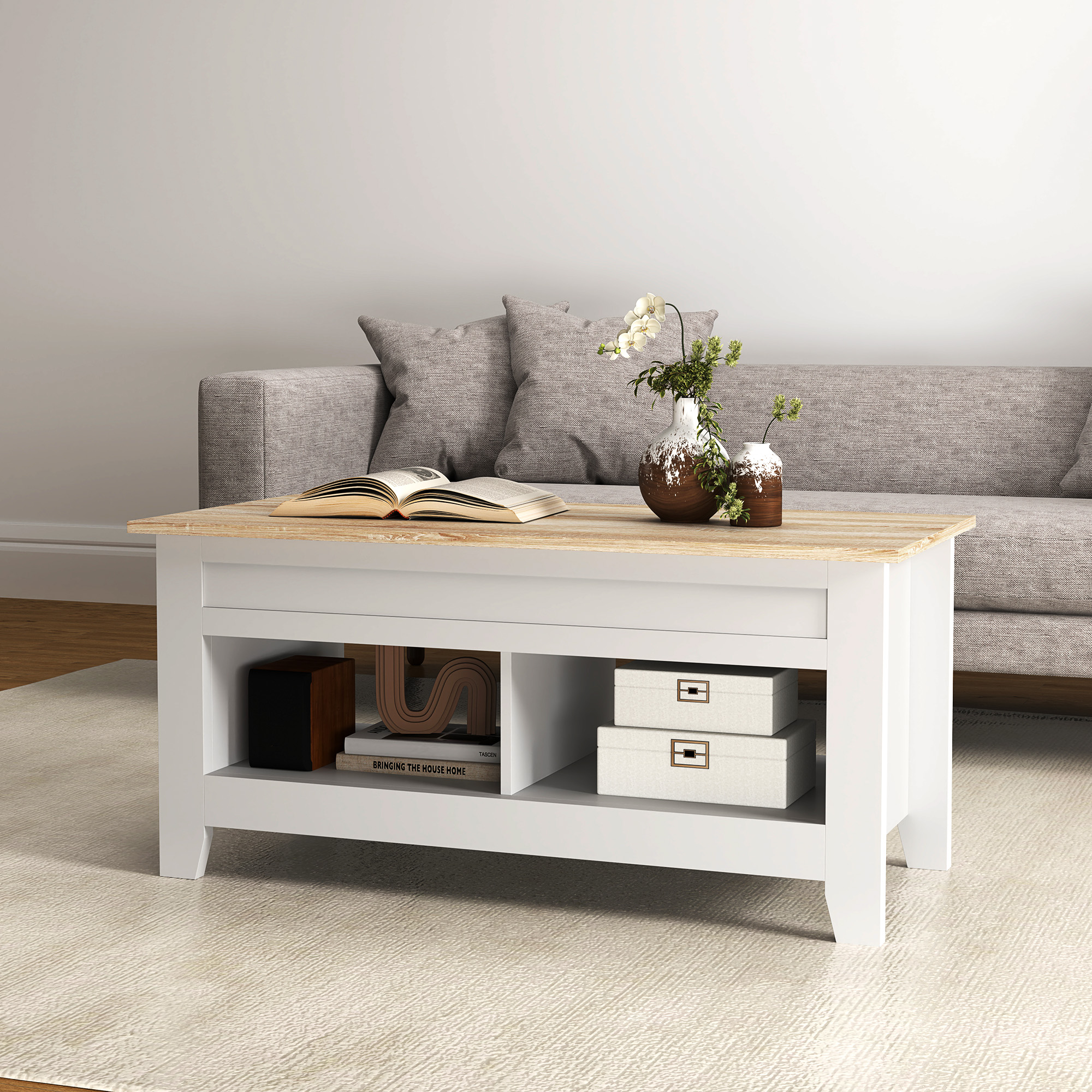 Una mesa de centro blanca con tapa de madera se sienta frente a un sofá. Hay libros y jarrones.