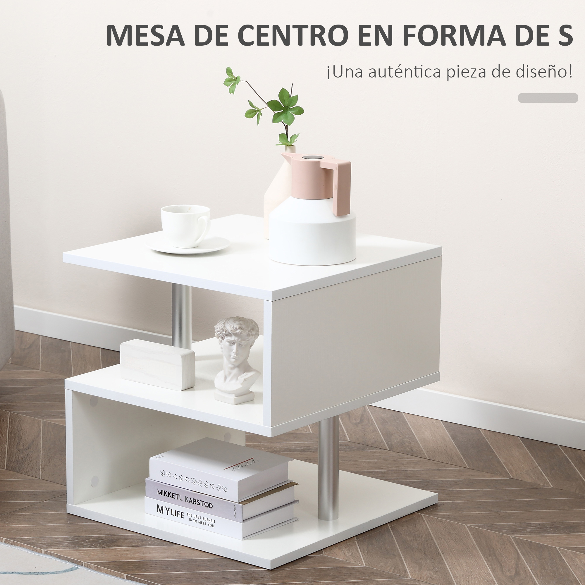 Una mesa de centro blanca de dos niveles decorada con una estatua y libros.