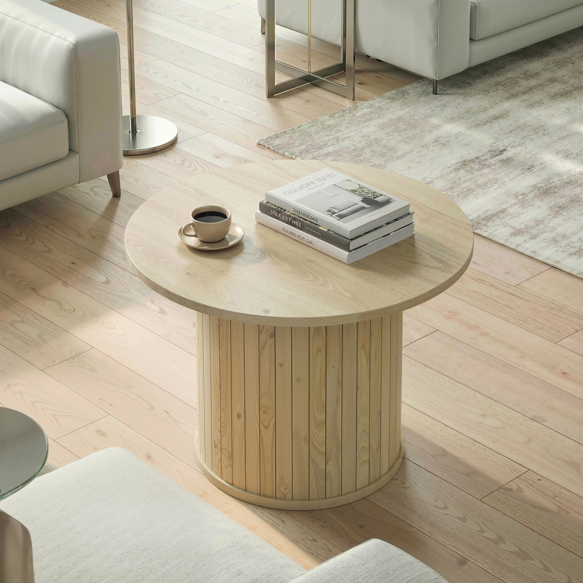 Una mesa redonda de madera con café y libros se asienta sobre un suelo de madera.