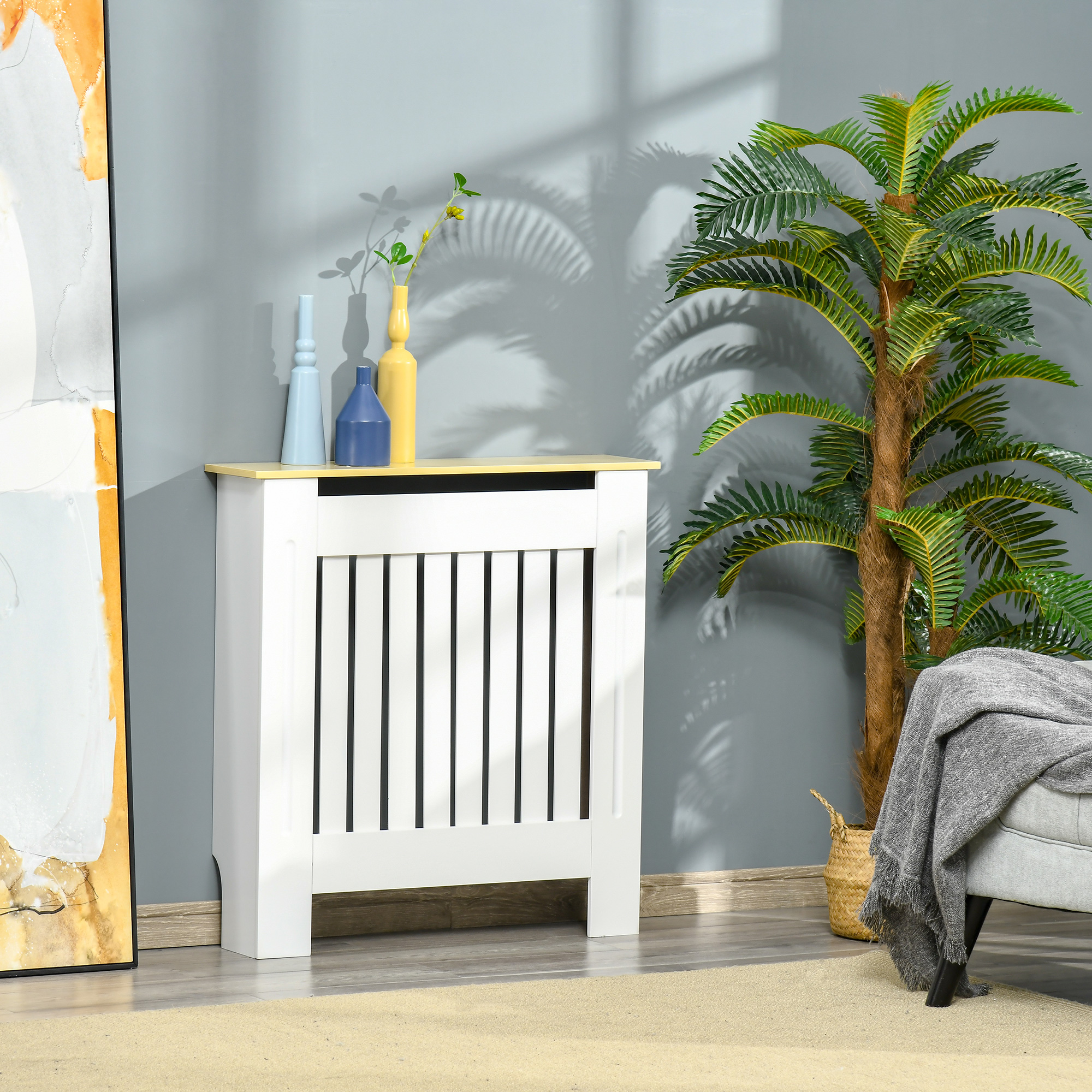 Funda de radiador blanca con tapa amarilla, decoración y planta.