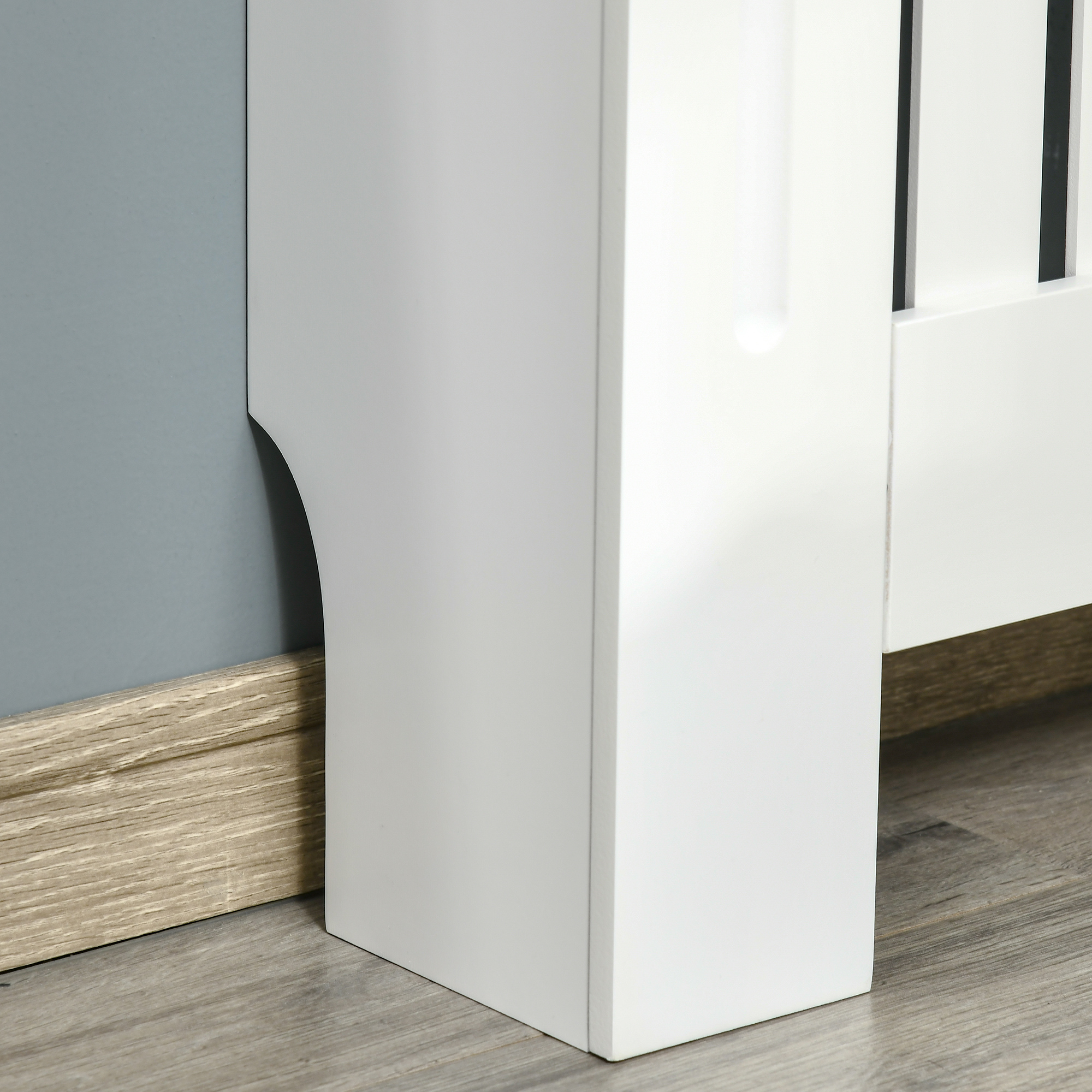 Esquina blanca de mueble junto a pared gris y suelo de madera.