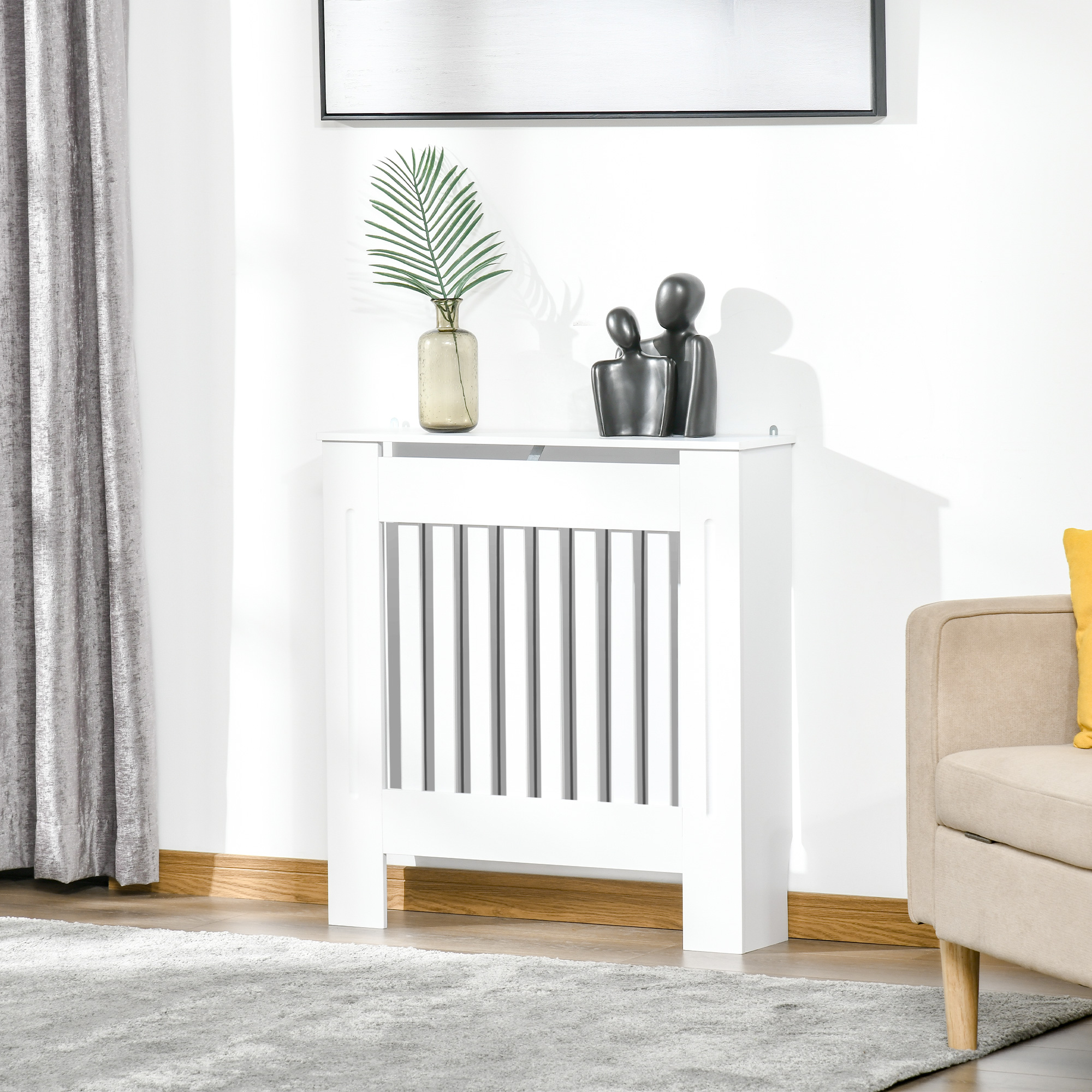 Un mueble blanco para cubrir el radiador con decoración encima.