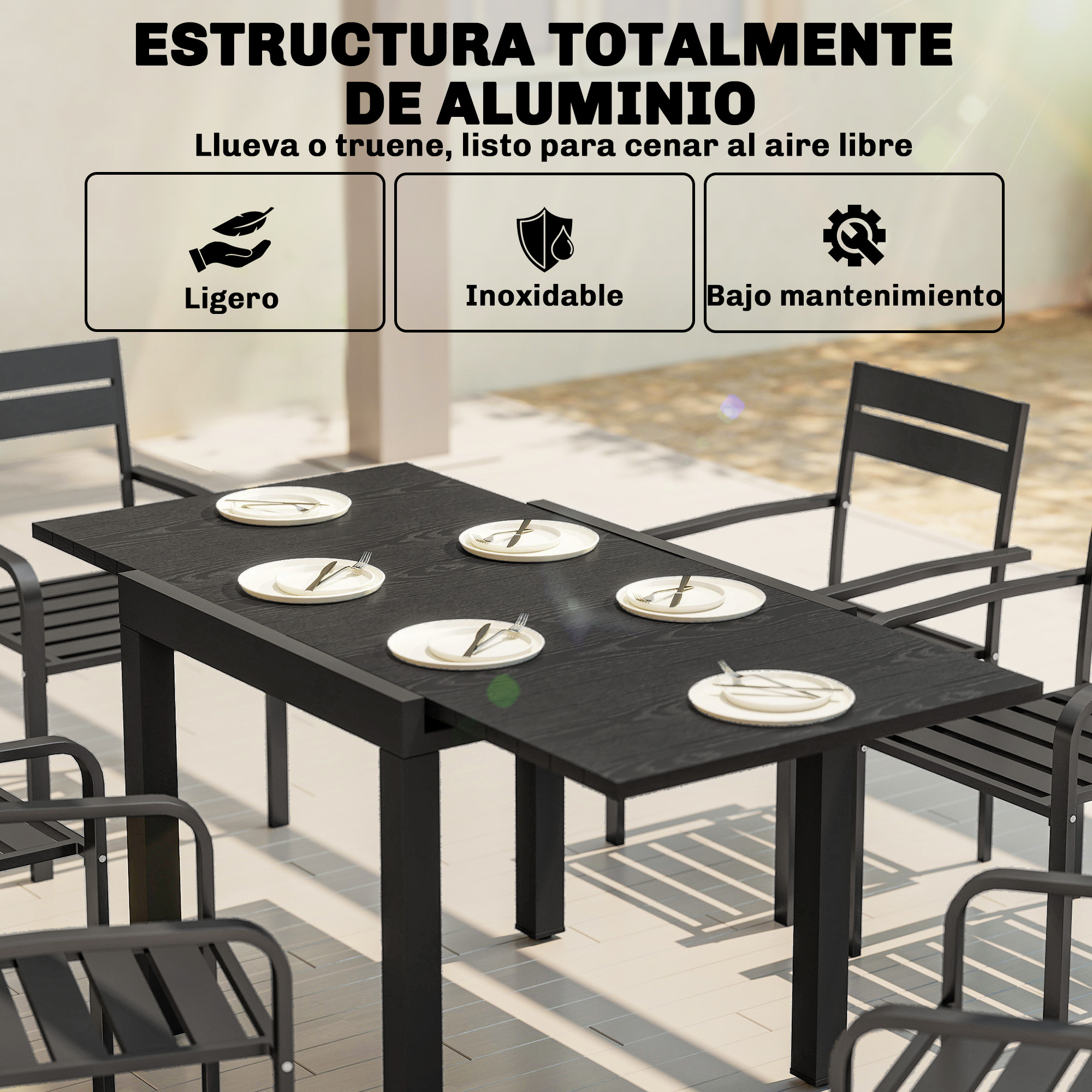 Mesa de comedor negra con platos y cubiertos, rodeada de sillas. Estructura de aluminio.