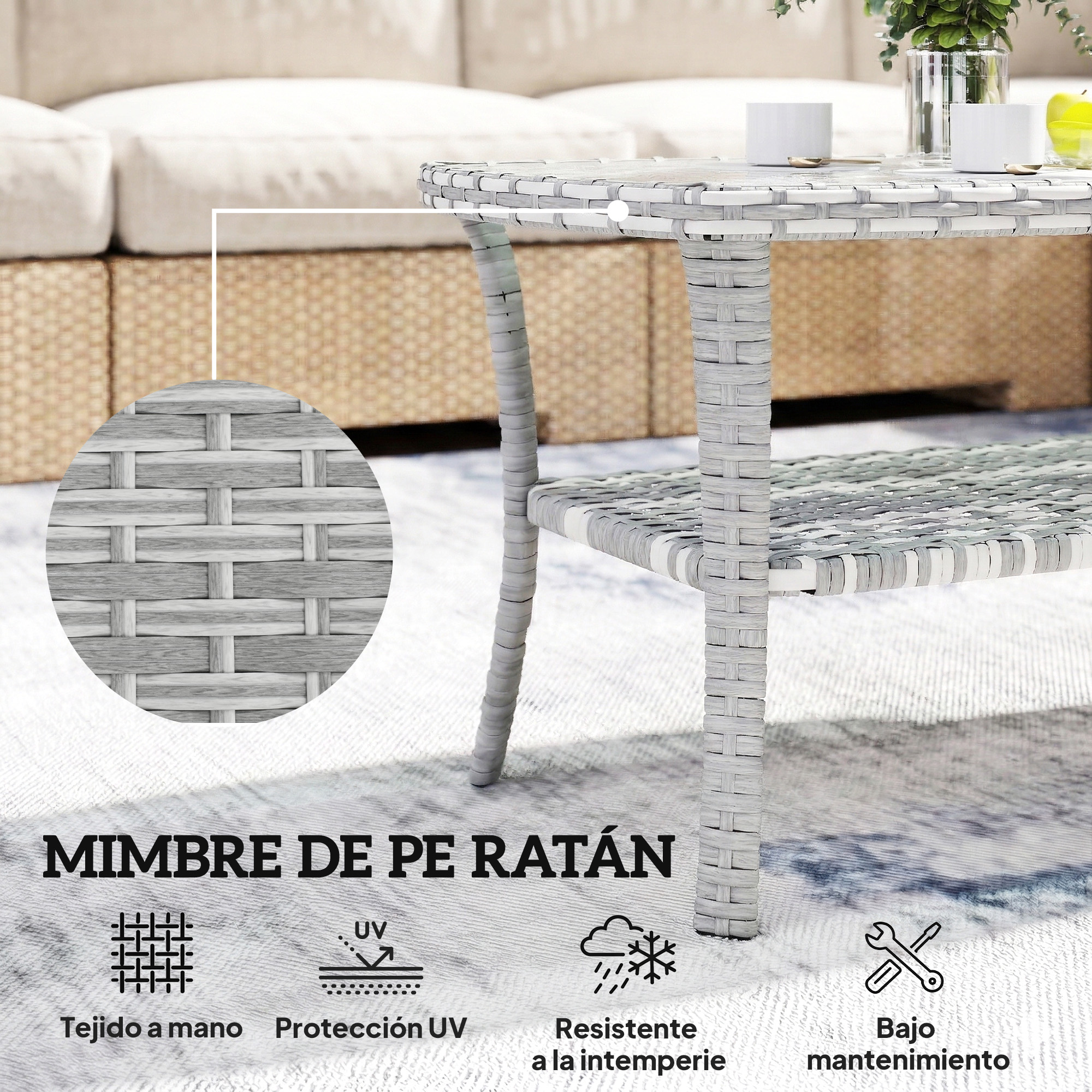 Mesa de centro de ratán gris con tapa de cristal, cojines y plantas.