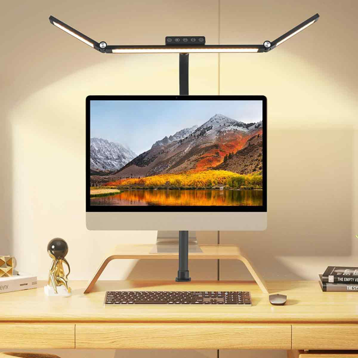 Ein Schreibtisch mit einem Monitor, Tastatur, Maus und einer Schreibtischlampe.