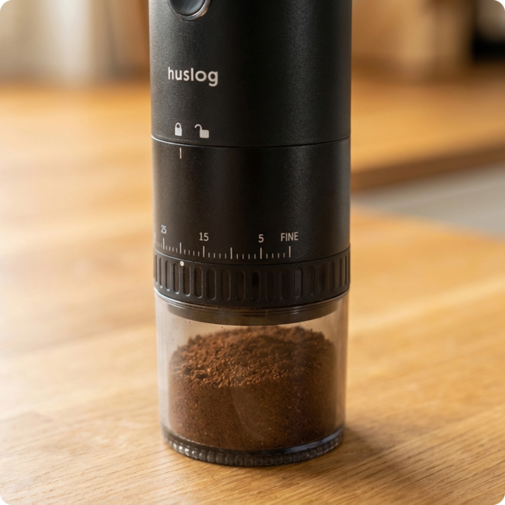 Czarny młynek do kawy z mieloną kawą w szklanym pojemniku.