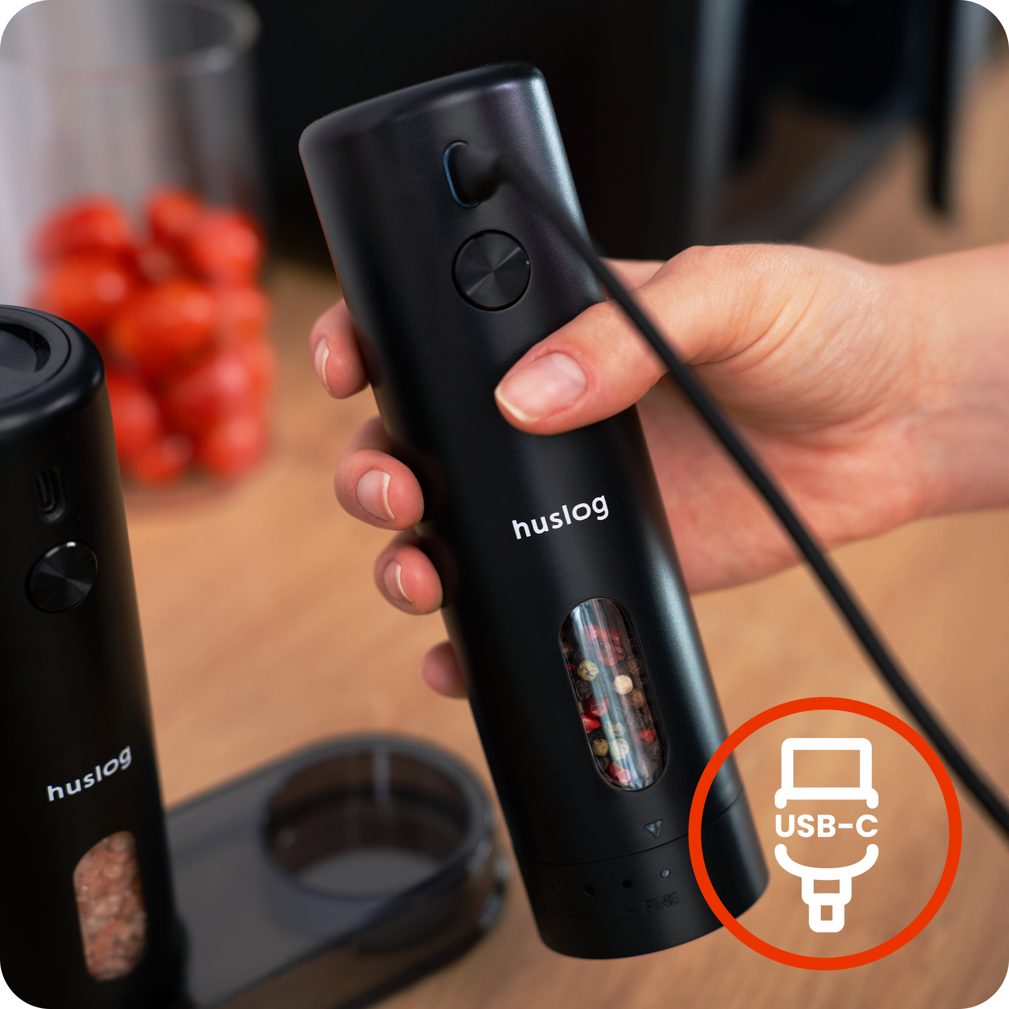 Ręka trzyma czarny elektryczny młynek do pieprzu z portem ładowania USB-C.