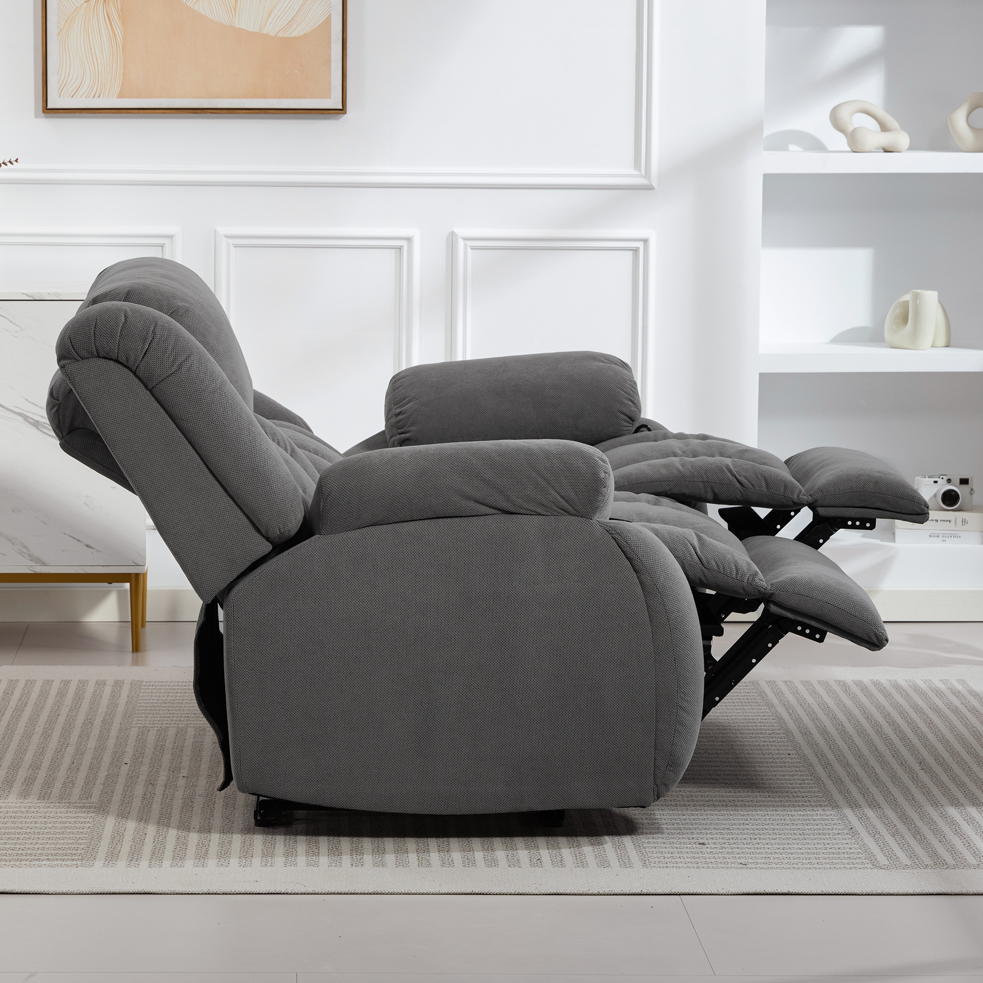 Un sillón reclinable gris con reposapiés extendidos sobre una alfombra.