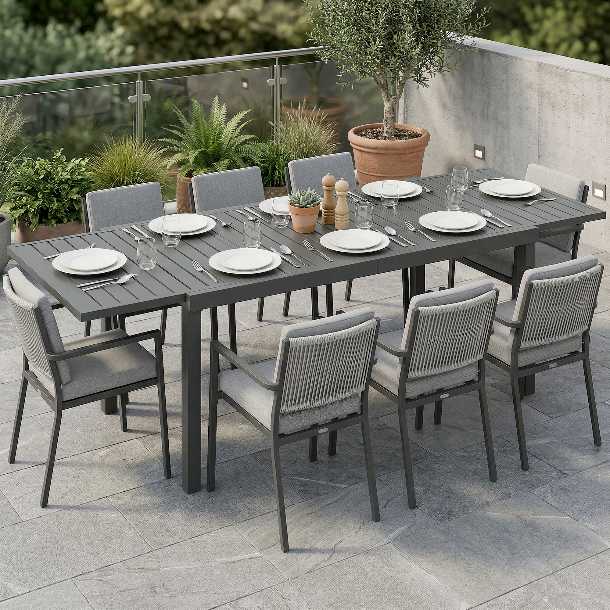 Una mesa de comedor exterior gris con ocho sillas, platos y vasos.