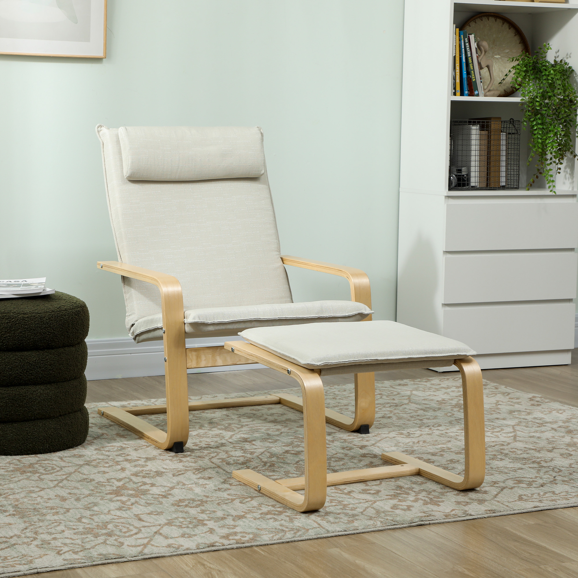 Un sillón beige con otomana y marco de madera sobre una alfombra.
