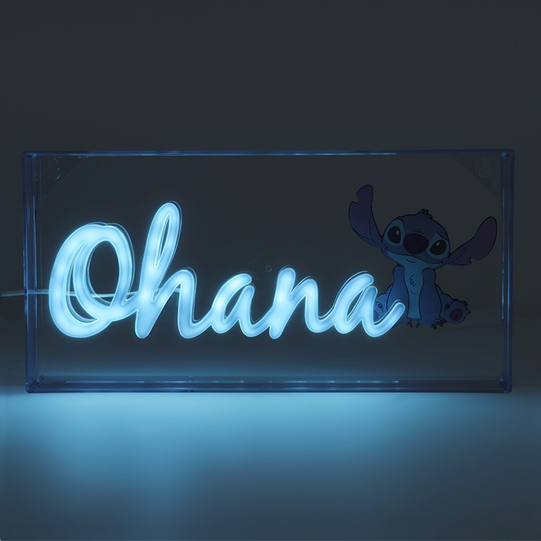 Niebieski neonowy napis 'Ohana' obok postaci Stitcha w przezroczystym pudełku.