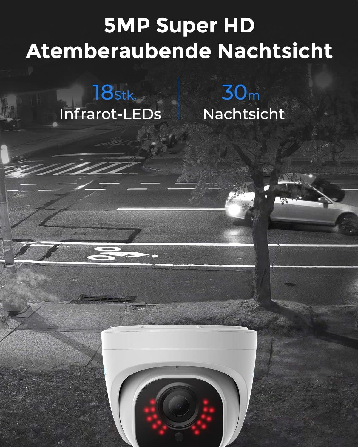 Eine weiße Überwachungskamera mit roten LEDs bei Nacht auf einer Straße.
