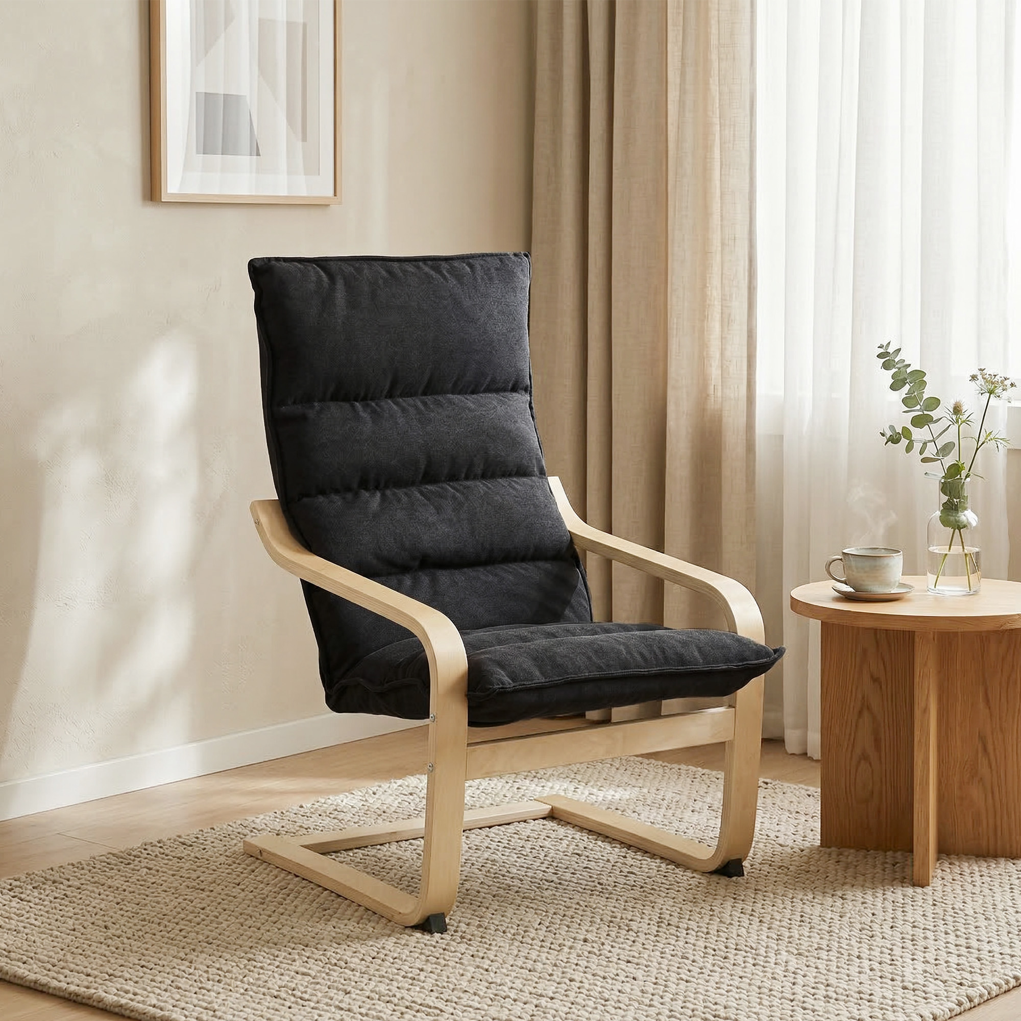 Un sillón negro con marco de madera está sobre una alfombra junto a una mesa de madera.