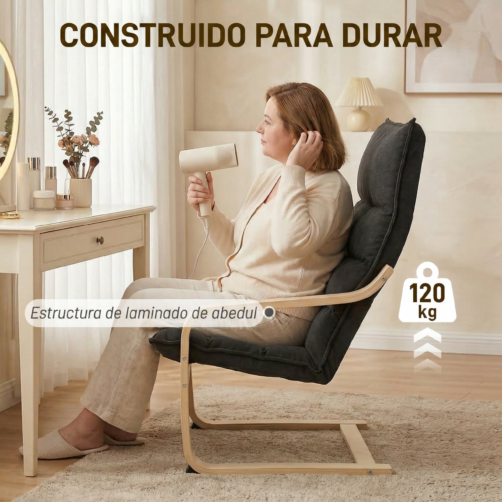 Una mujer se sienta en una silla oscura sosteniendo un secador de pelo. Hay cosméticos en una mesa.