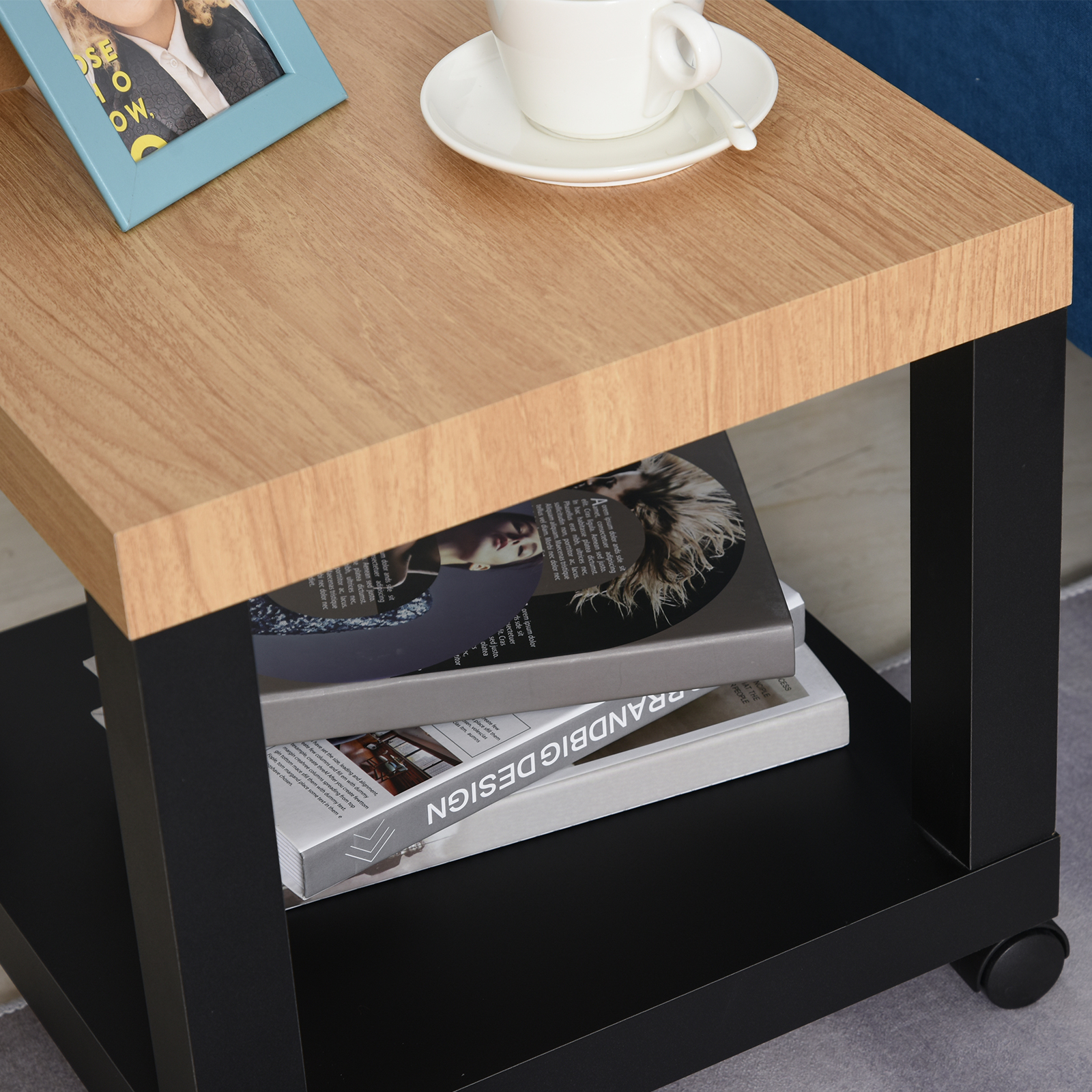 Una mesa de madera con libros, una taza y un marco de fotos.