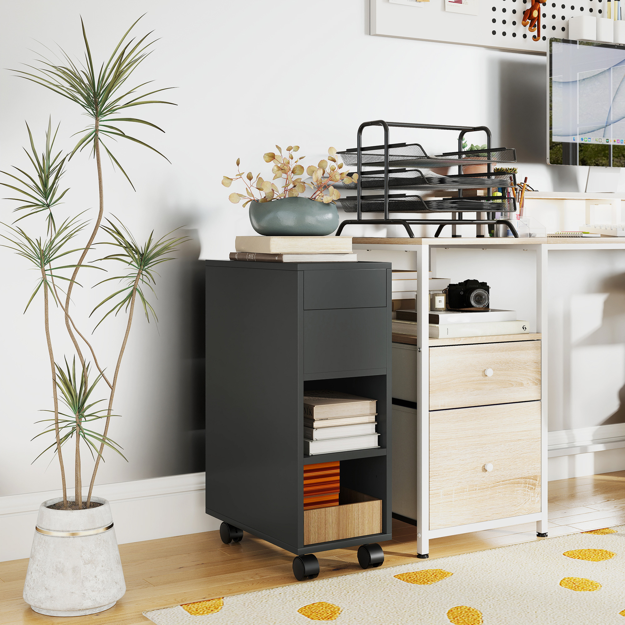 Un archivador móvil gris oscuro con libros y una planta junto a un escritorio con computadora.